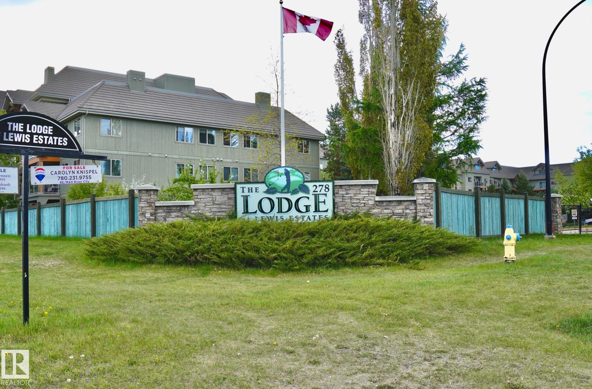 Stone-clad monument sign featuring "The Lodge Lewis Estates" with a Canadian flag - 237 278 Suder Greens Drive, Edmonton, AB - Indoor Photo Showing Other Room