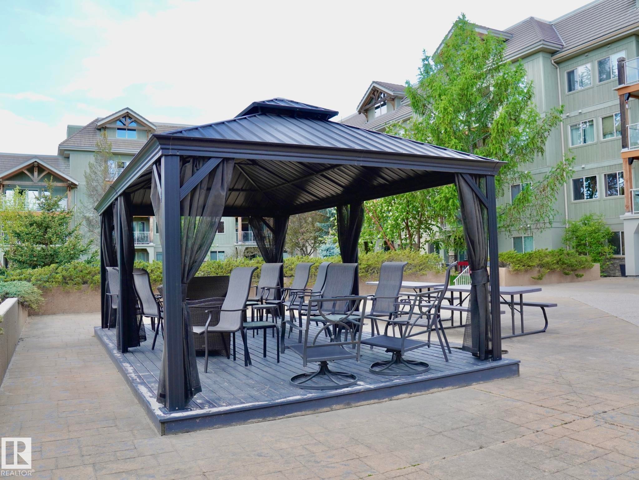 Outdoor gazebo featuring a metal roof, dark screening, and a raised wood-finish deck - 237 278 Suder Greens Drive, Edmonton, AB - Outdoor With Facade