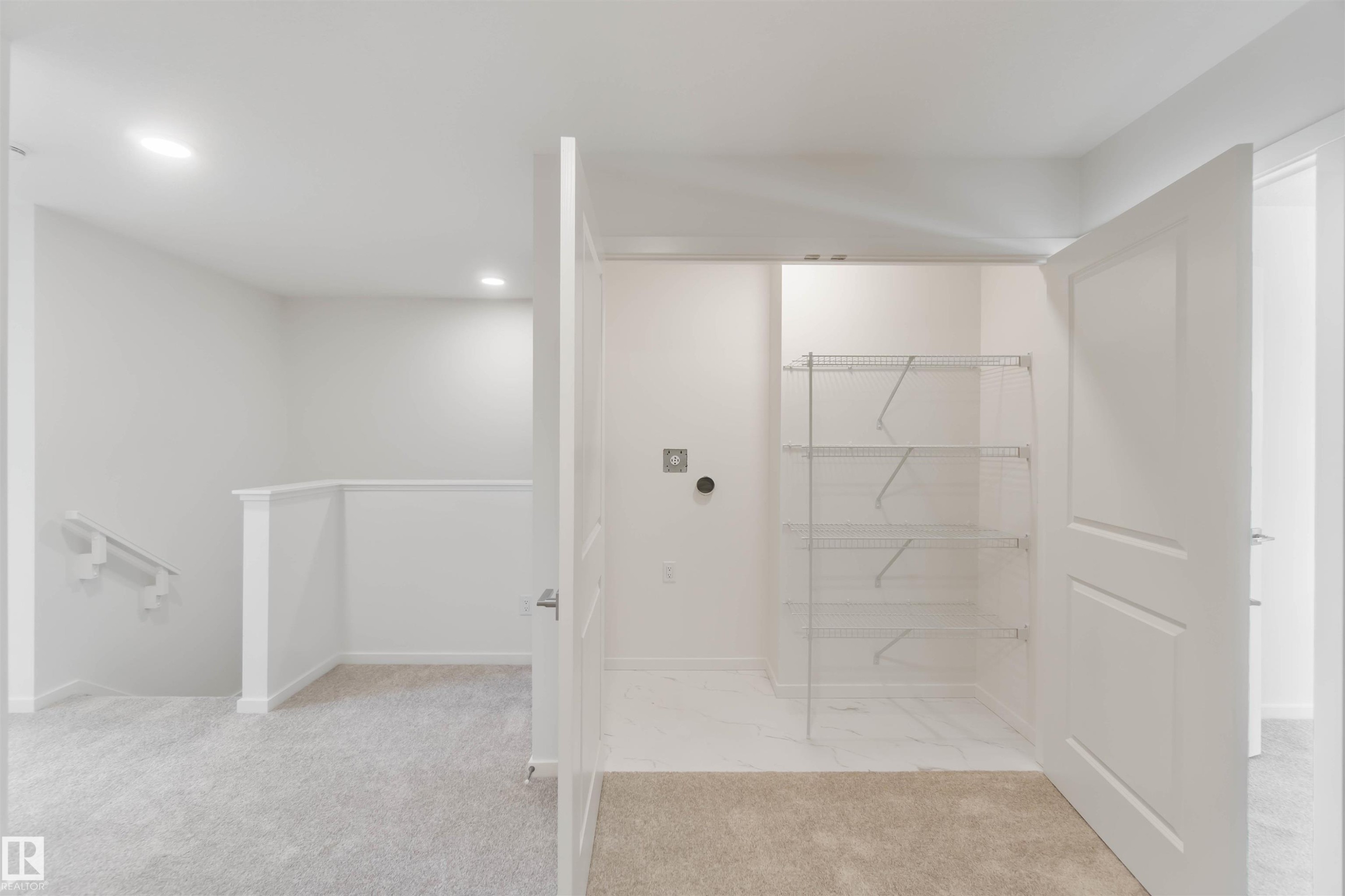 Walk in closet featuring light carpet and light marble finish flooring - 2467 Alces Link Link, Edmonton, AB - Indoor