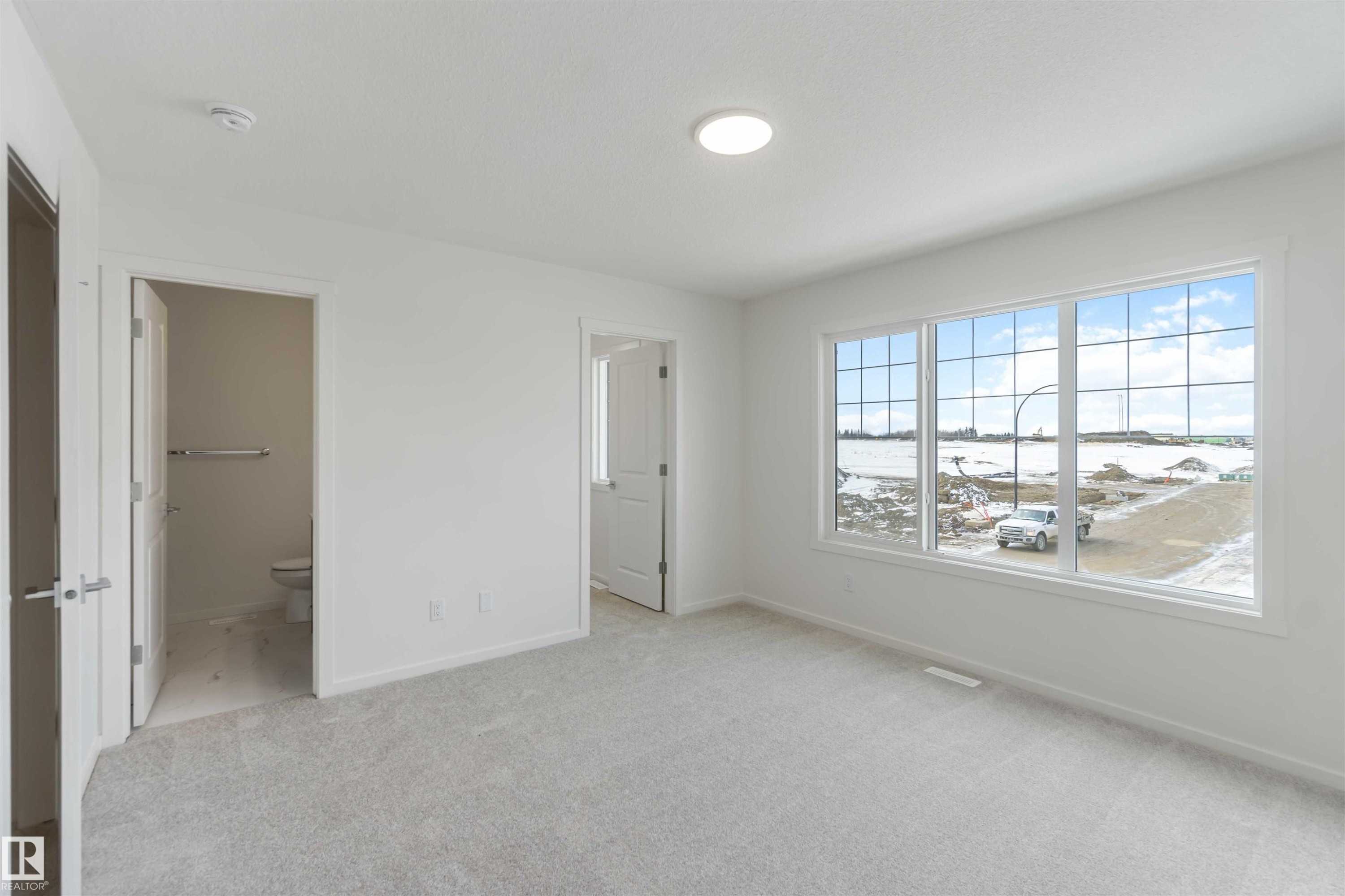 Unfurnished bedroom featuring light carpet and connected bathroom - 2467 Alces Link Link, Edmonton, AB - Indoor Photo Showing Other Room