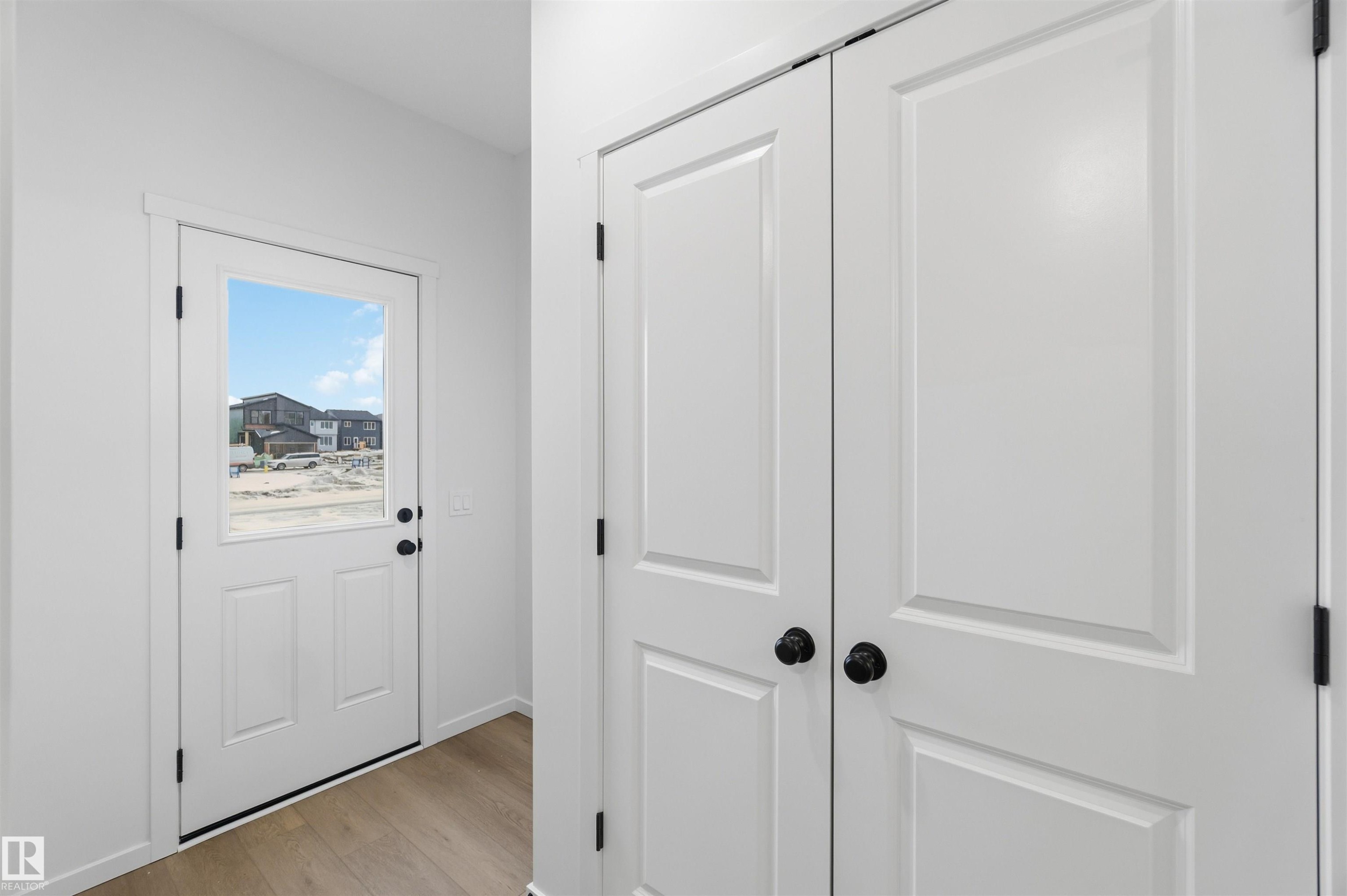 Doorway to outside with wood finished floors and baseboards - 8652 Edgemont Link, Edmonton, AB - Indoor Photo Showing Other Room