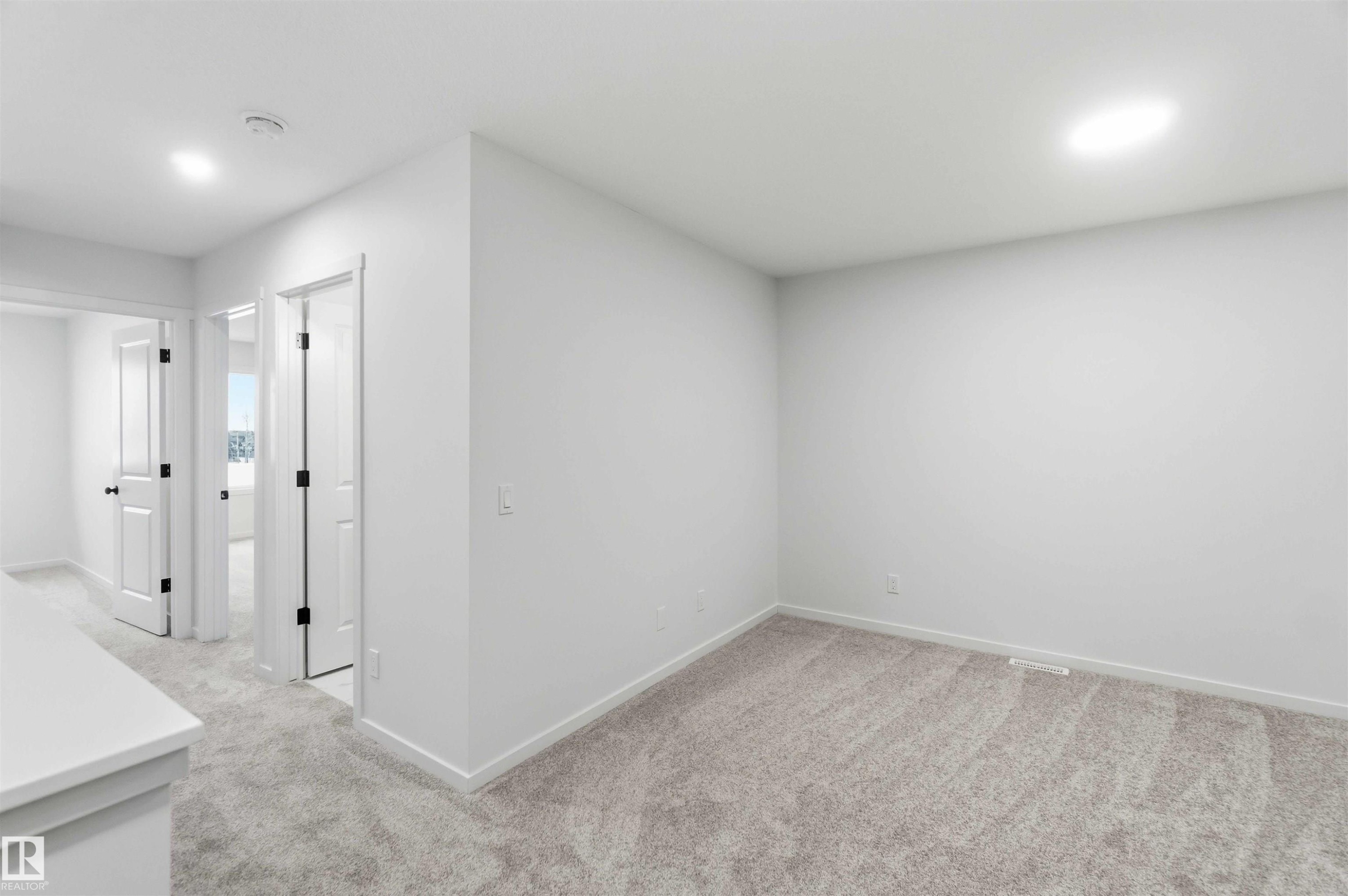Interior space with light carpet and recessed lighting - 8652 Edgemont Link, Edmonton, AB - Indoor Photo Showing Other Room