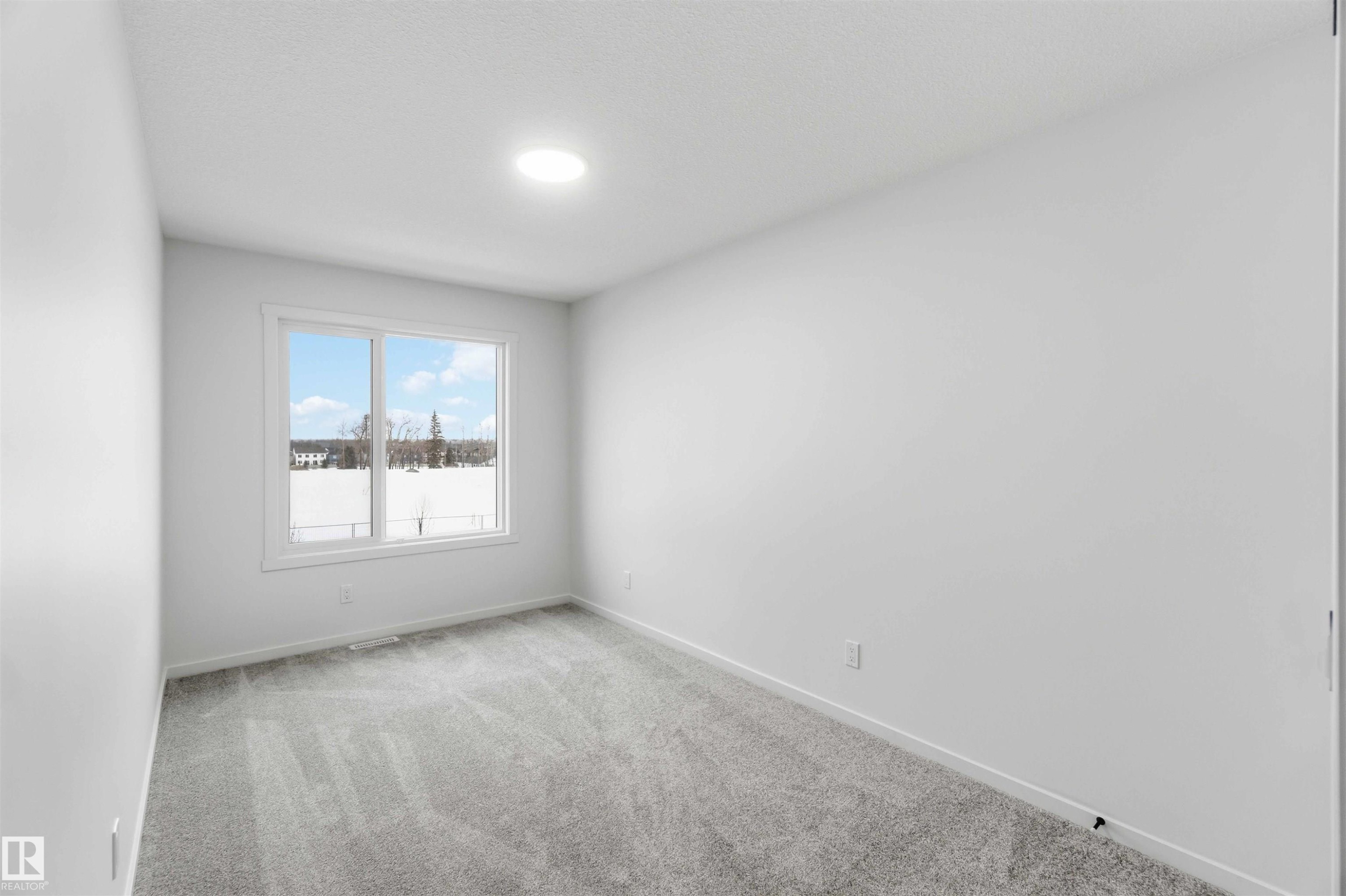 Spare room featuring light colored carpet and baseboards - 8652 Edgemont Link, Edmonton, AB - Indoor Photo Showing Other Room