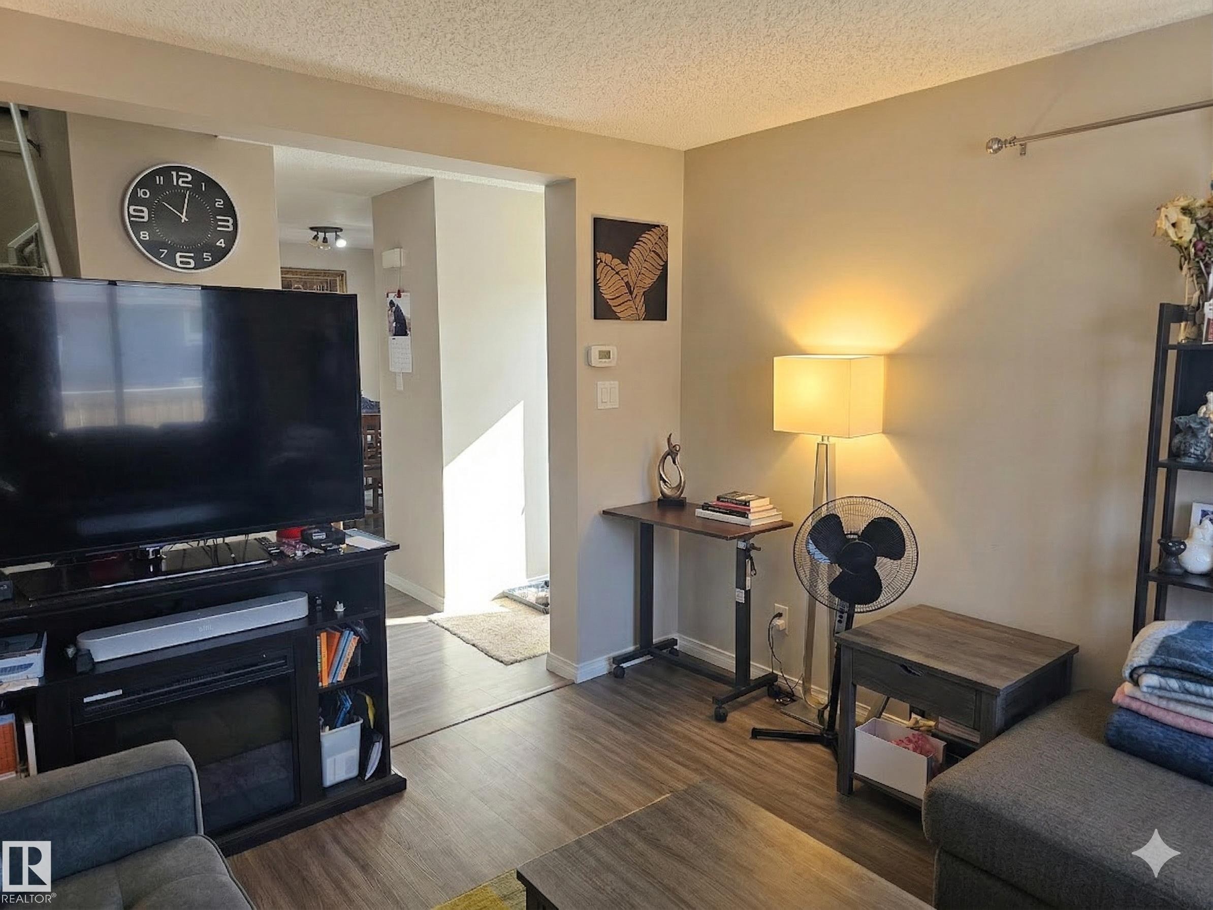 Living room with wood finished floors and a textured ceiling - 223 Kaskitayo Crest, Edmonton, AB - Indoor Photo Showing Living Room