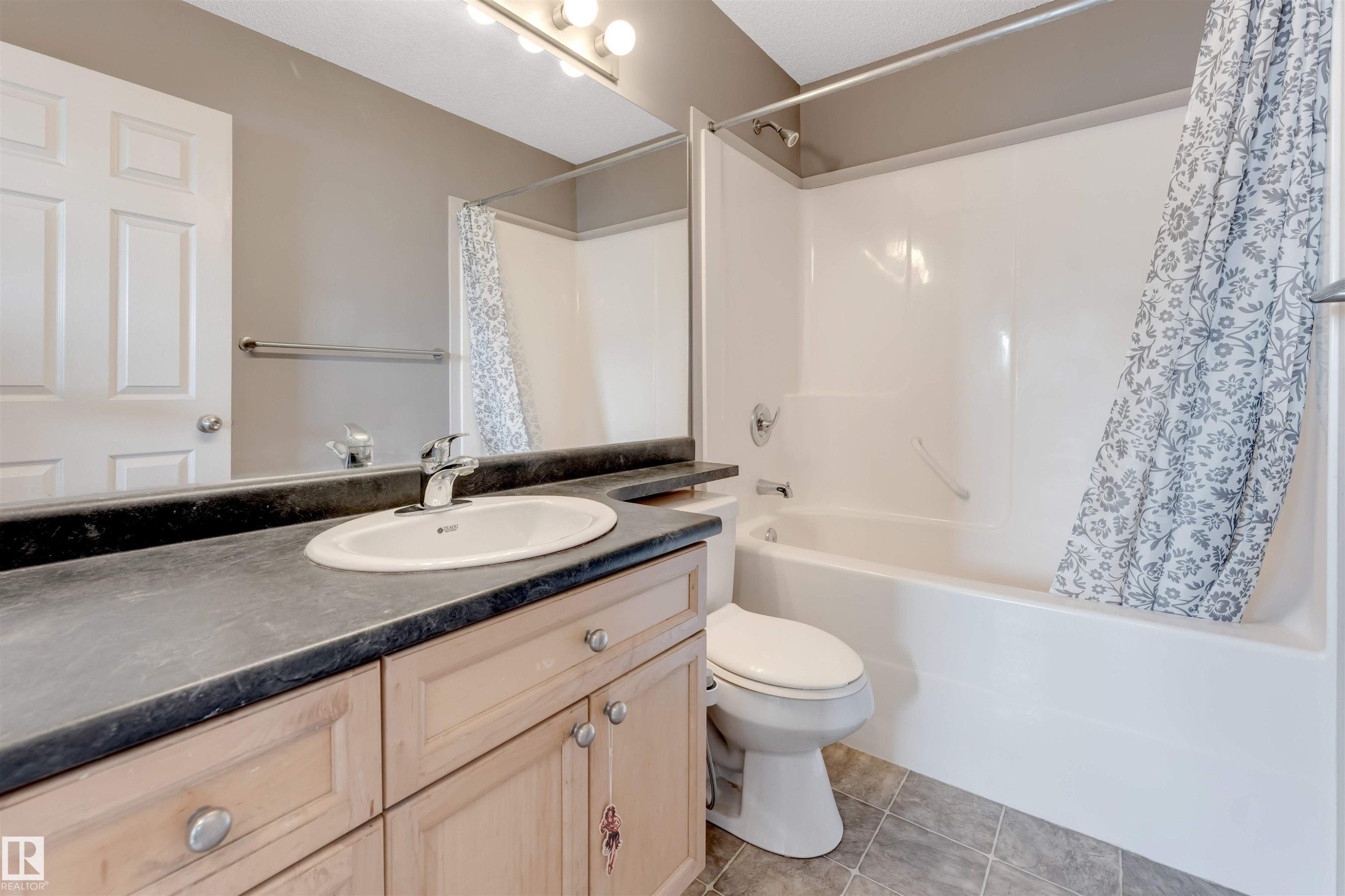 Full bathroom with vanity, shower / tub combo, and light tile patterned flooring - 1157 37 Avenue, Edmonton, AB - Indoor Photo Showing Bathroom