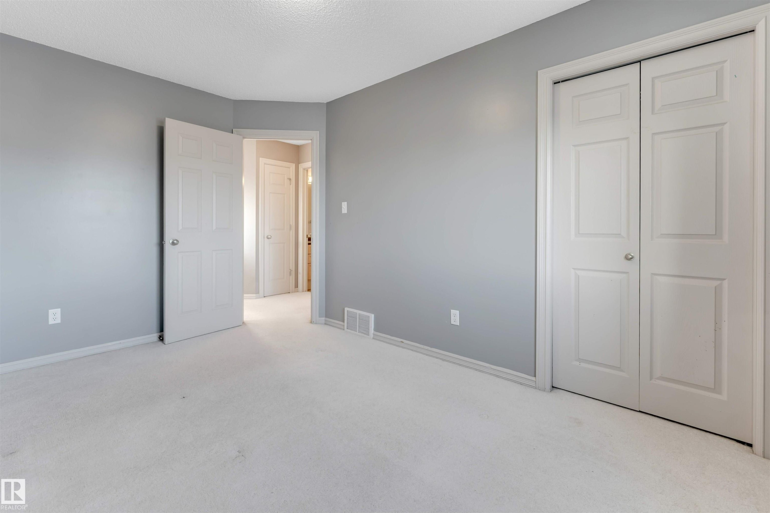 Unfurnished bedroom with light colored carpet, a closet, and a textured ceiling - 1157 37 Avenue, Edmonton, AB - Indoor Photo Showing Other Room