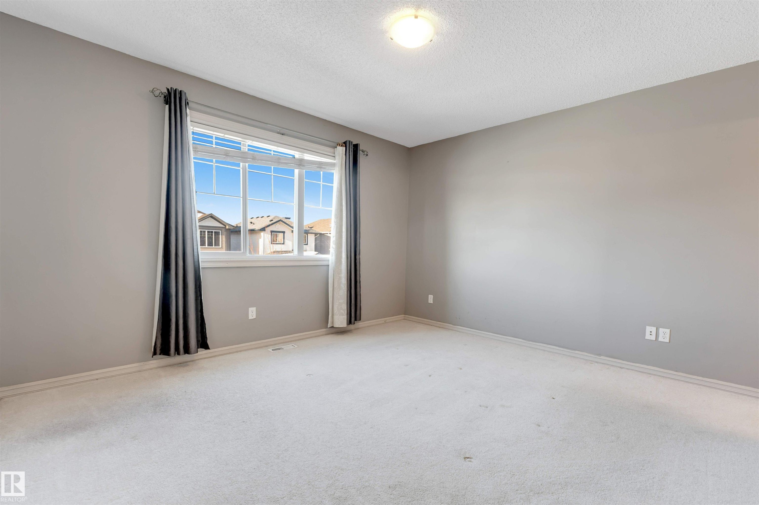 Empty room featuring light carpet and a textured ceiling - 1157 37 Avenue, Edmonton, AB - Indoor Photo Showing Other Room