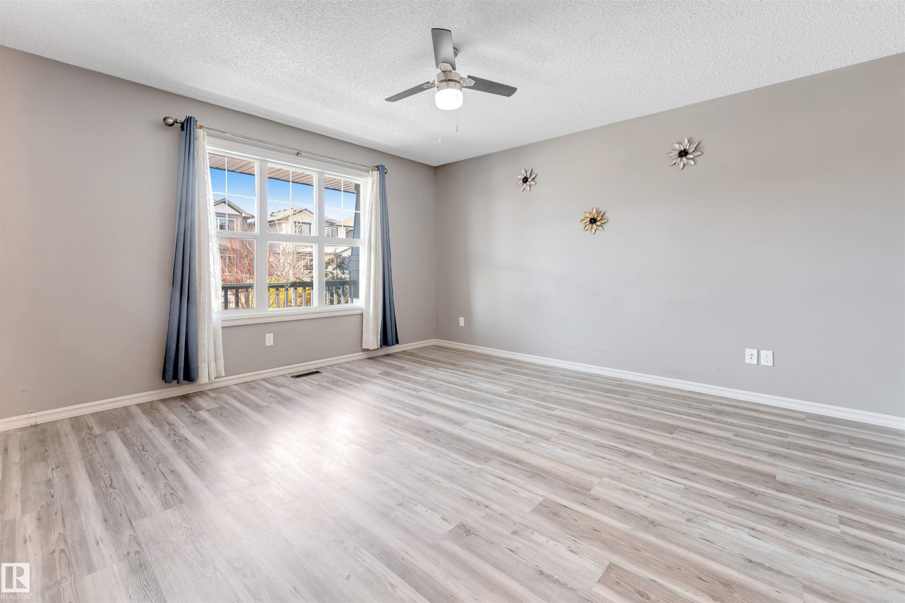 Empty room featuring a ceiling fan, light wood-style floors, and a textured ceiling - 1157 37 Avenue, Edmonton, AB - Indoor Photo Showing Other Room