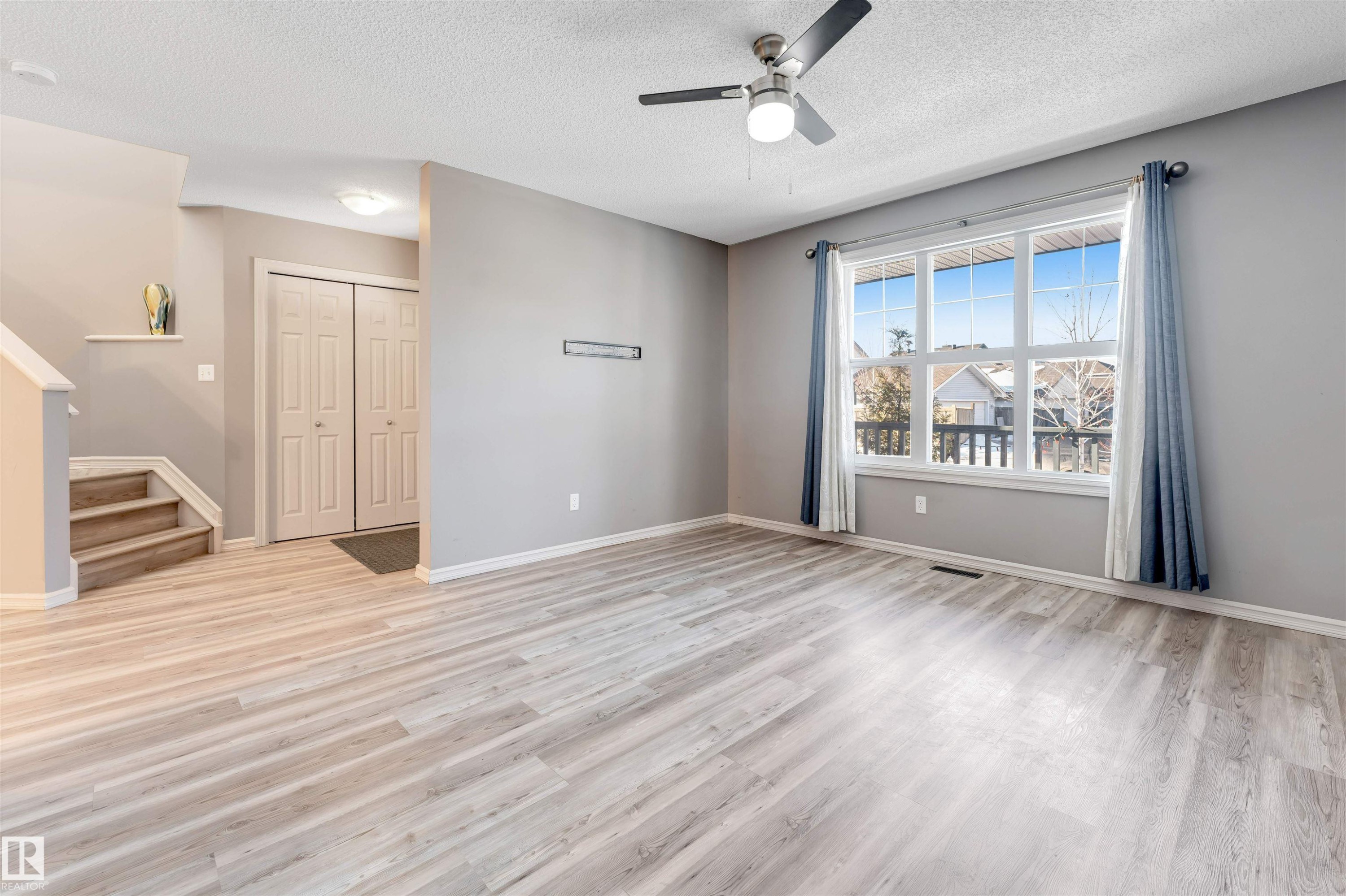 Unfurnished living room featuring ceiling fan, light wood-style floors, and a textured ceiling - 1157 37 Avenue, Edmonton, AB - Indoor Photo Showing Other Room