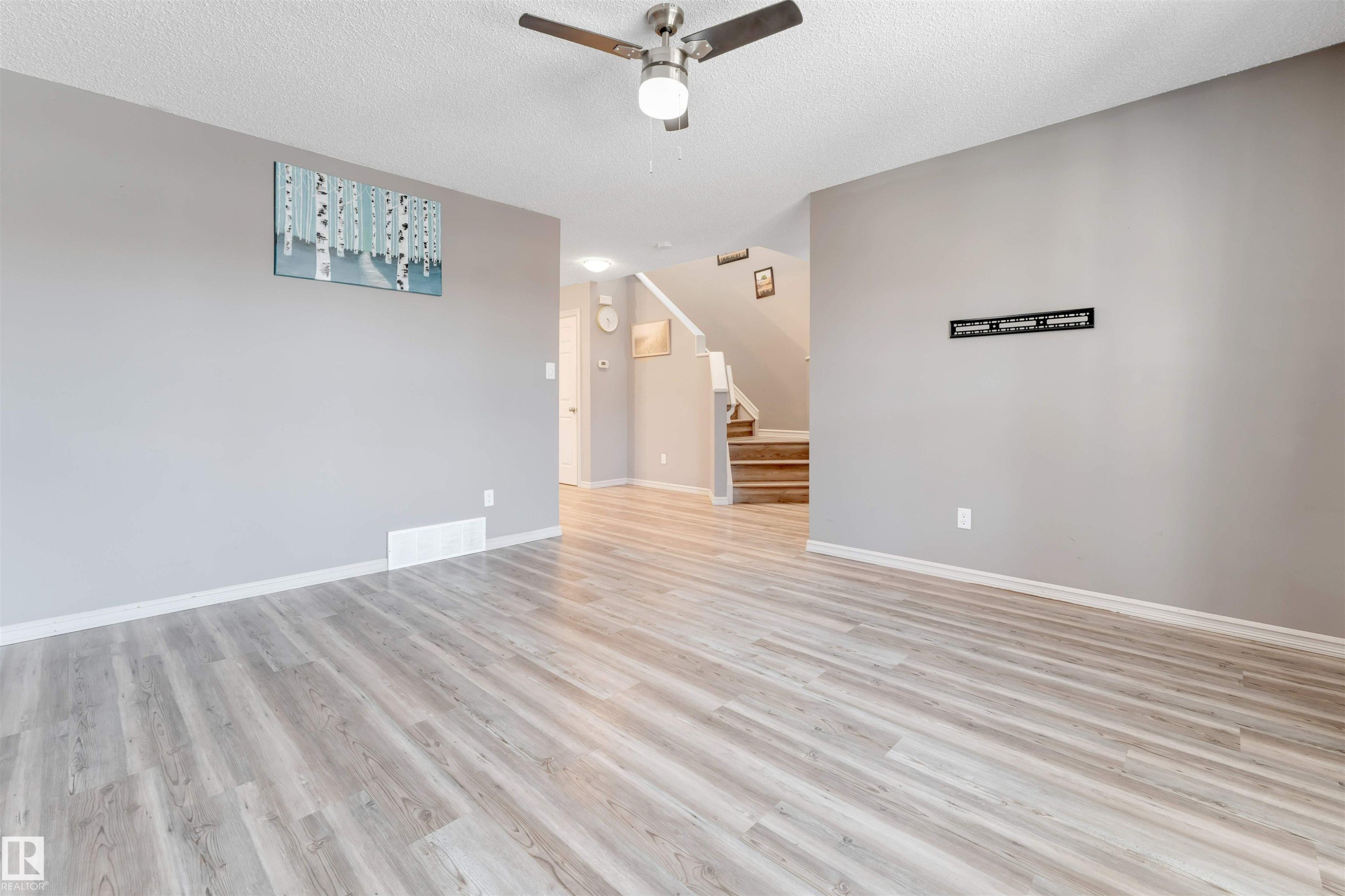 Empty room featuring ceiling fan, a textured ceiling, and light wood-style floors - 1157 37 Avenue, Edmonton, AB - Indoor Photo Showing Other Room