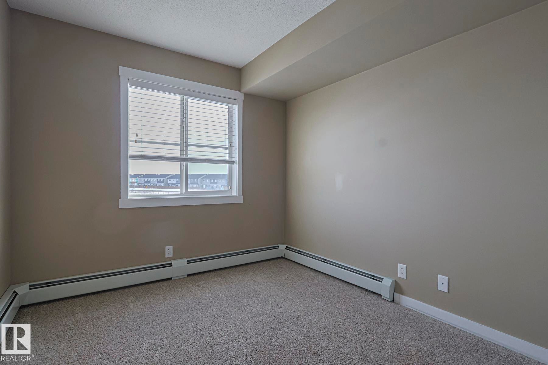 This room features a window with blinds, light-colored walls, and carpeting - 313 1510 Watt Drive, Edmonton, AB - Indoor Photo Showing Other Room