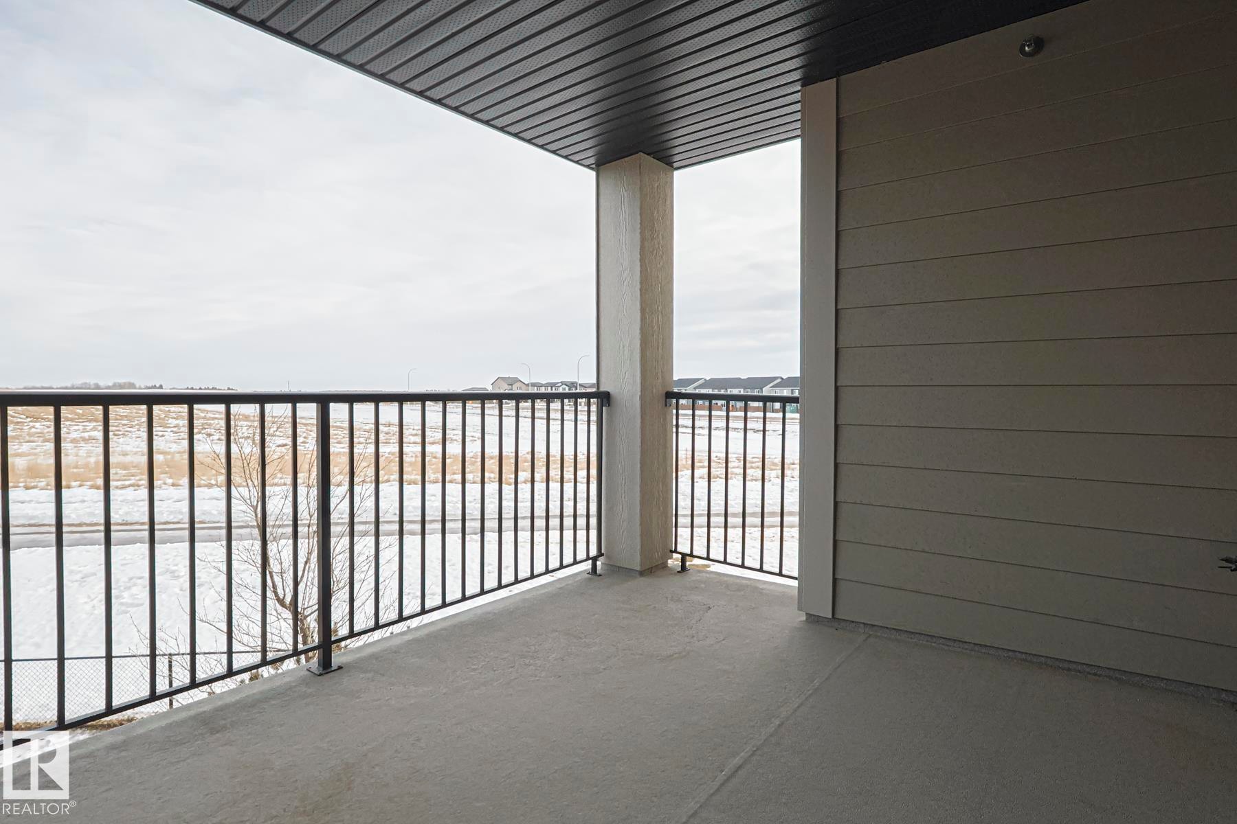 The property features a balcony with a concrete floor, dark metal railings, and a solid overhead covering - 313 1510 Watt Drive, Edmonton, AB - Outdoor With Balcony With Exterior