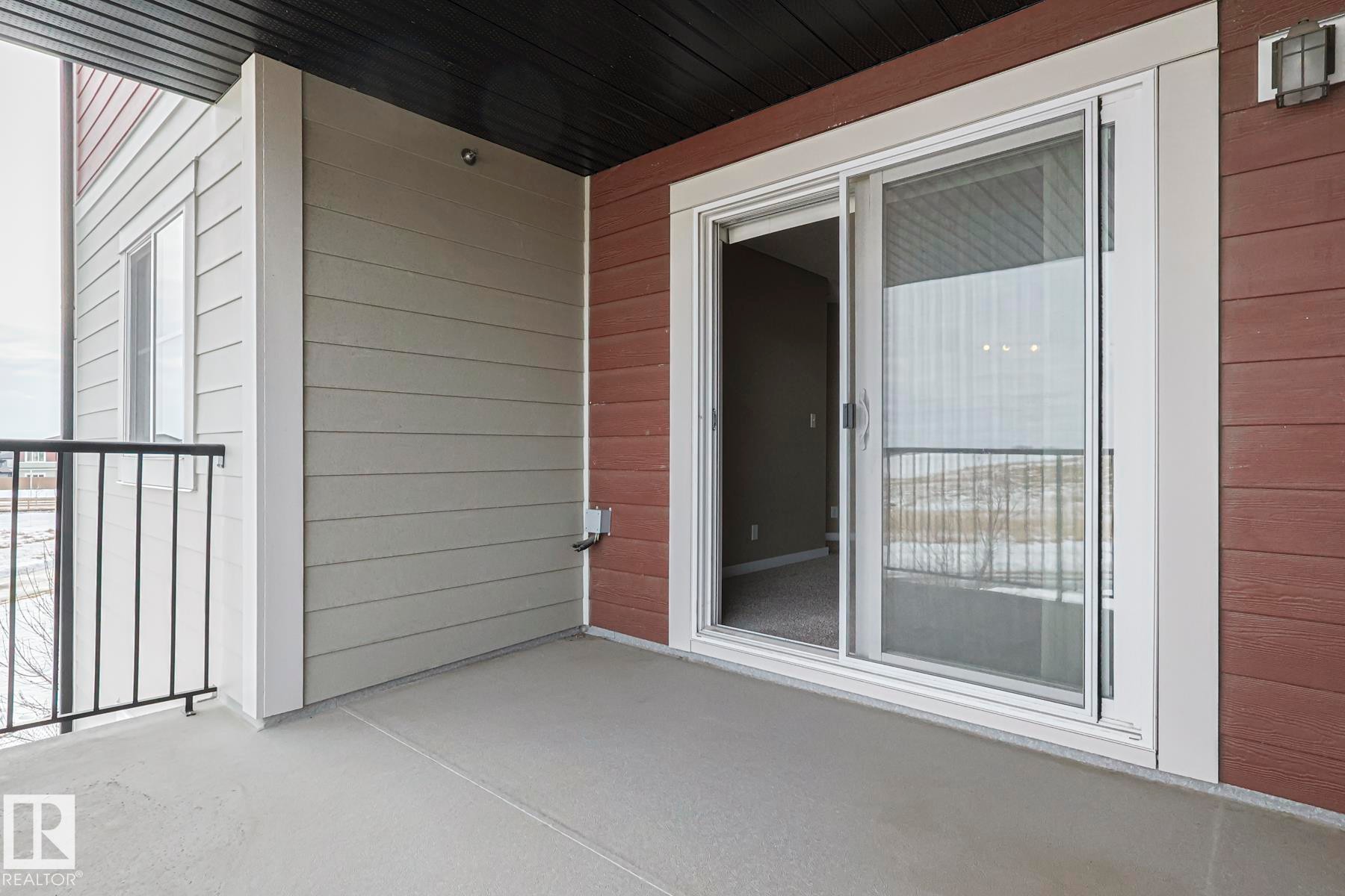 The property features a balcony with a concrete floor and a black metal railing - 313 1510 Watt Drive, Edmonton, AB - Outdoor With Exterior
