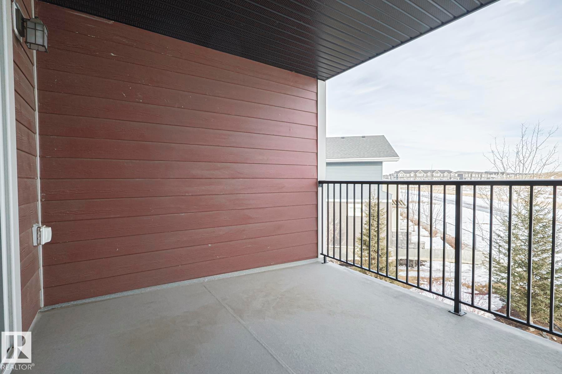 The property features a private balcony with a concrete floor and black metal railings, offering an outdoor living space - 313 1510 Watt Drive, Edmonton, AB - Outdoor With Balcony With Exterior