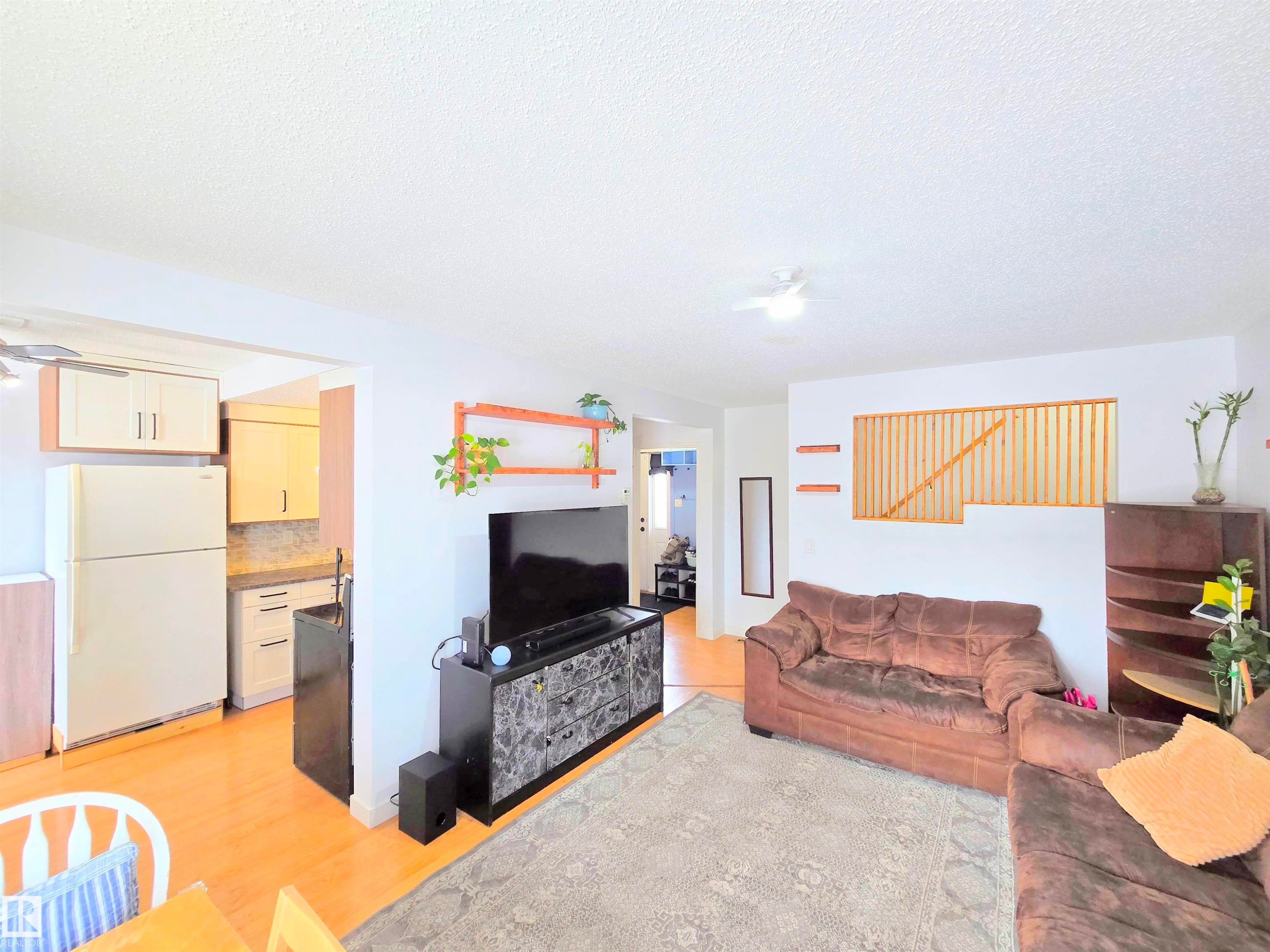 Living room featuring light wood-style floors, a ceiling fan, and a textured ceiling - 80 Amberly Crest, Edmonton, AB - Indoor Photo Showing Other Room