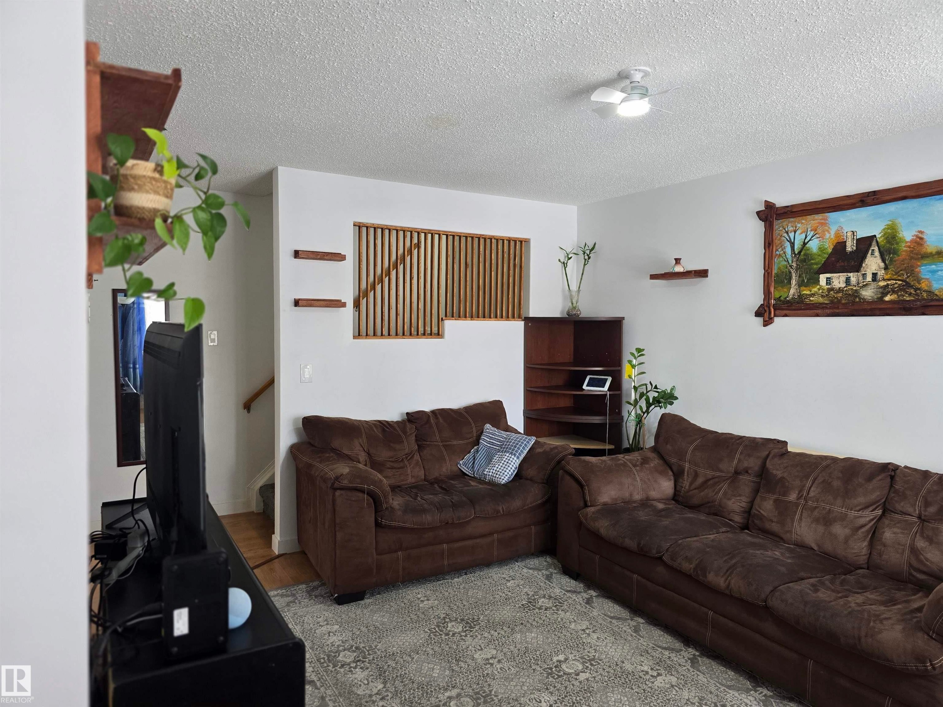 The property features a spacious living area with white walls and a textured ceiling - 80 Amberly Crest, Edmonton, AB - Indoor Photo Showing Living Room