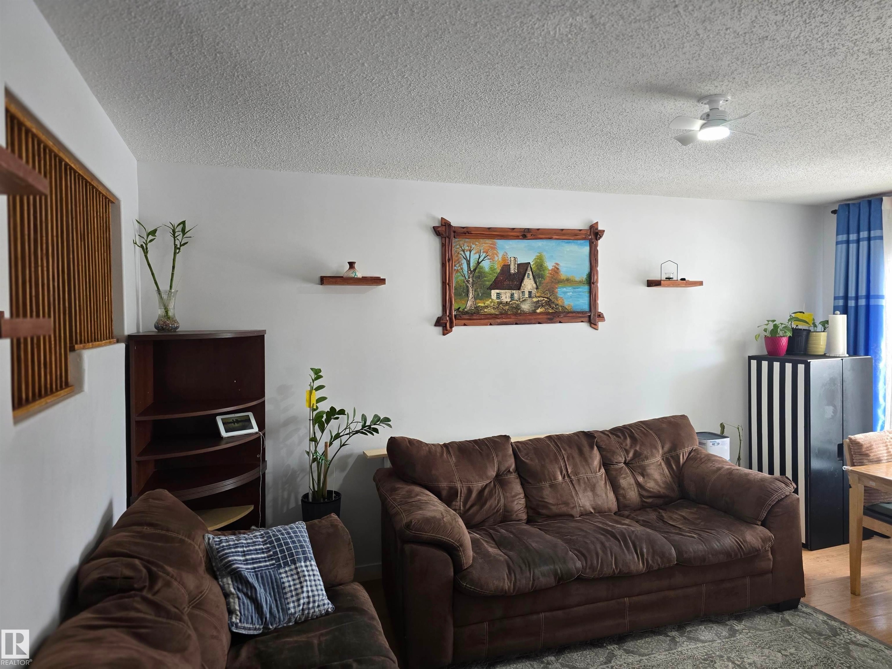 The living area features white walls, a ceiling fan with integrated lighting, and hardwood flooring - 80 Amberly Crest, Edmonton, AB - Indoor Photo Showing Living Room