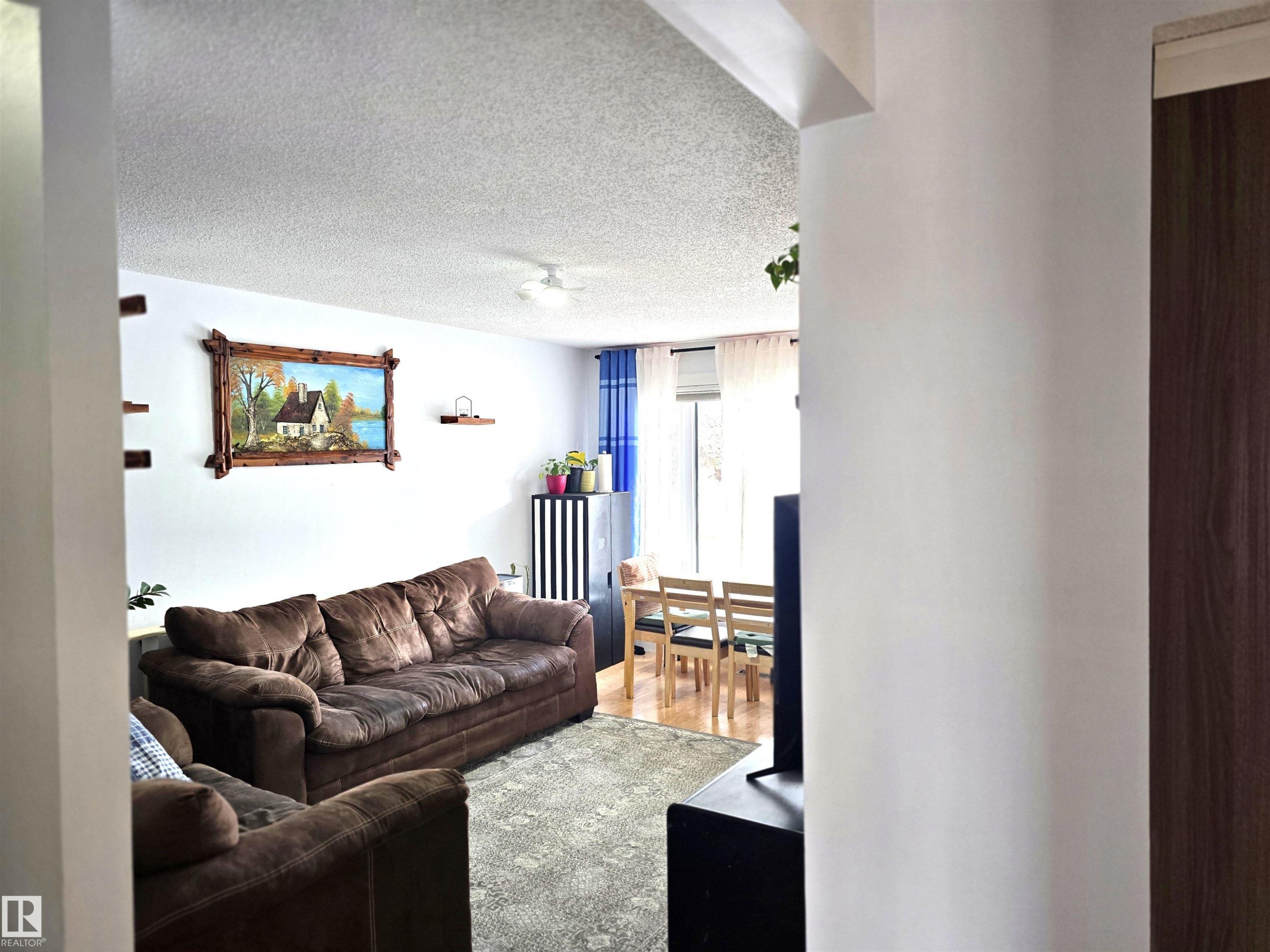 Living area featuring light-colored walls and a textured ceiling - 80 Amberly Crest, Edmonton, AB - Indoor Photo Showing Living Room