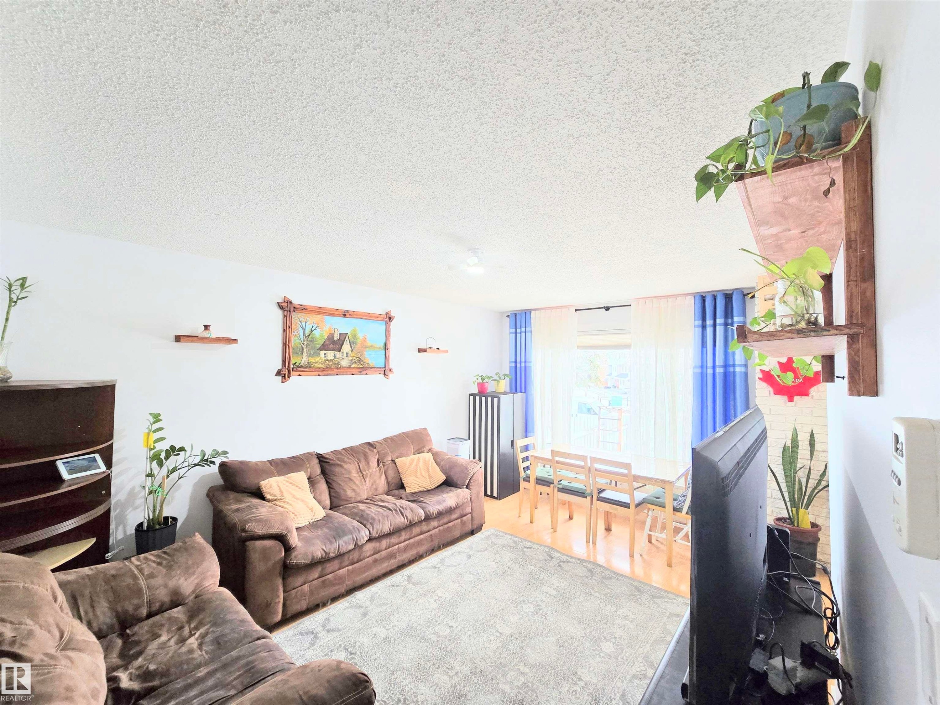 Living room featuring wood finished floors and a textured ceiling - 80 Amberly Crest, Edmonton, AB - Indoor Photo Showing Living Room