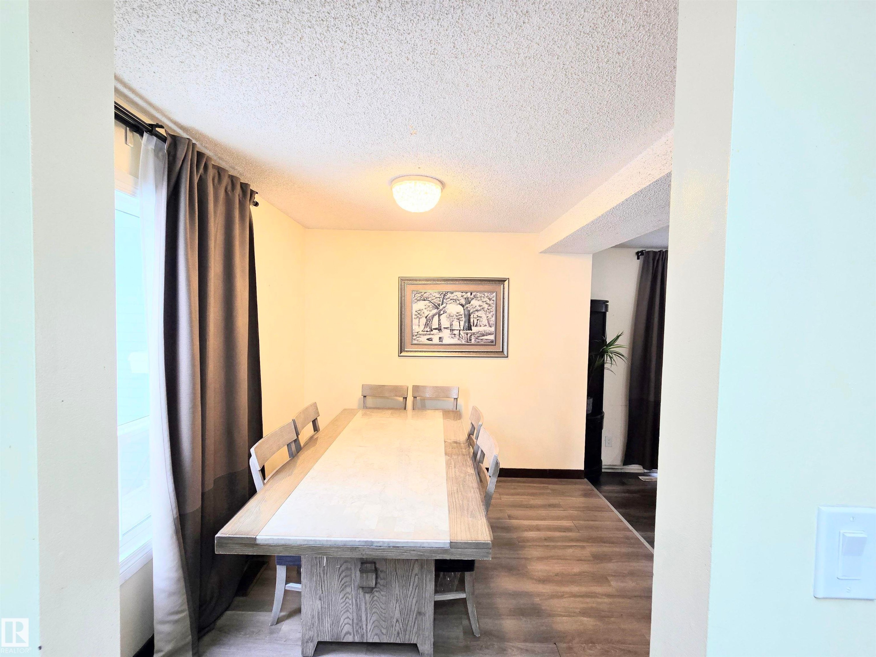 Dining space with a textured ceiling and dark wood-style floors - 2 4403 Riverbend Road, Edmonton, AB - Indoor Photo Showing Dining Room