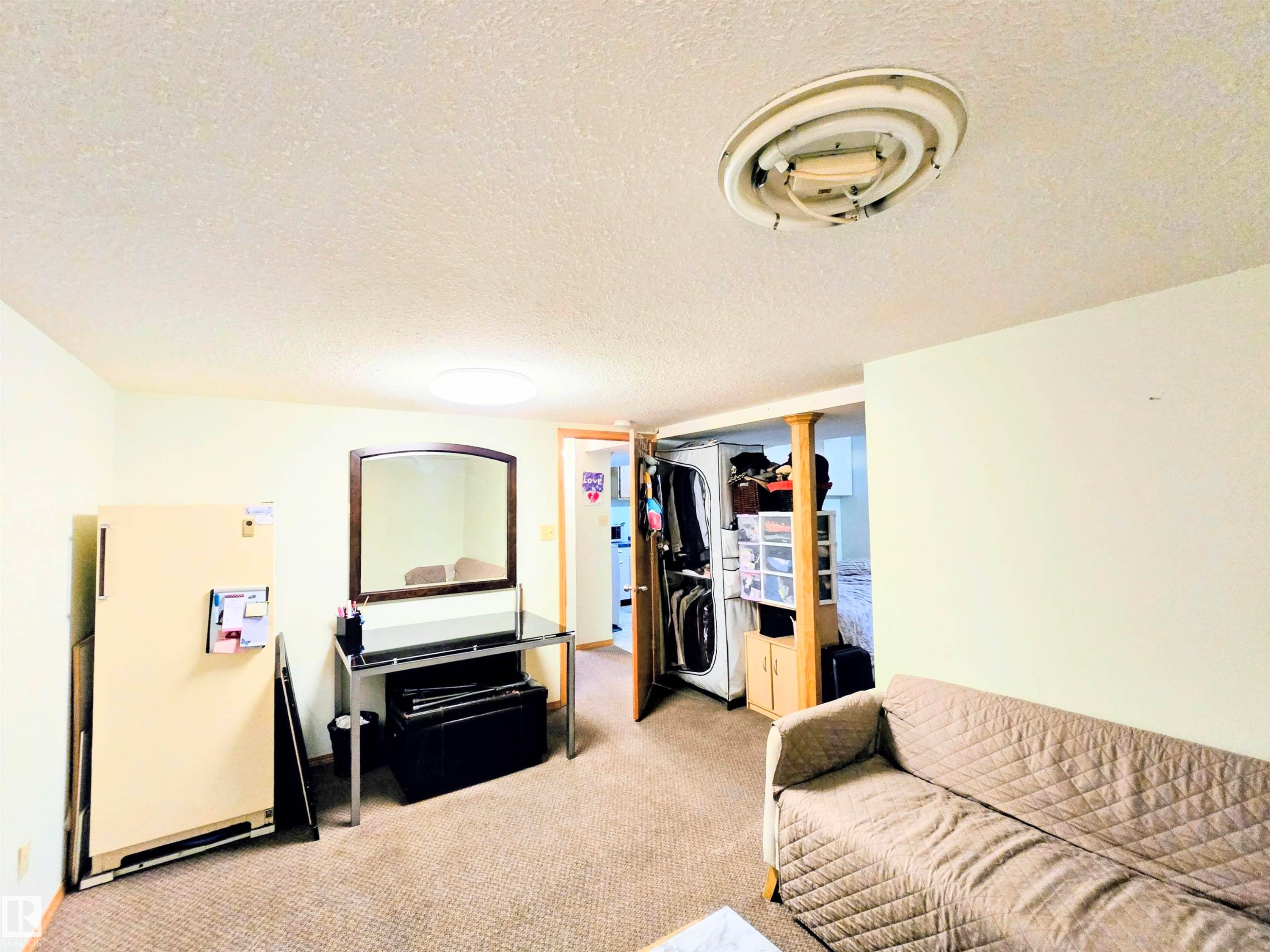 Living room with a textured ceiling and light colored carpet - 2 4403 Riverbend Road, Edmonton, AB - Indoor