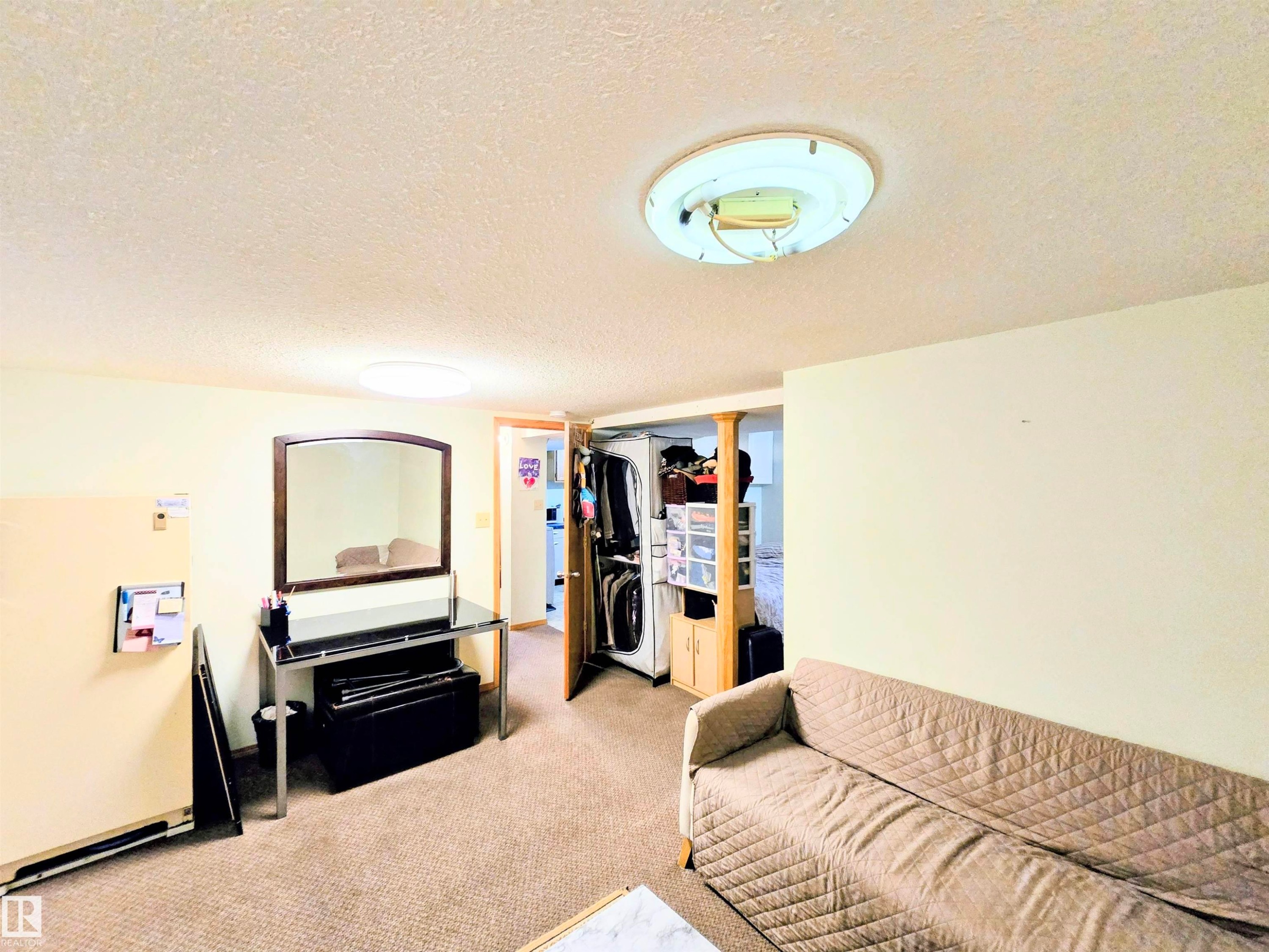 Carpeted living room featuring a textured ceiling - 2 4403 Riverbend Road, Edmonton, AB - Indoor
