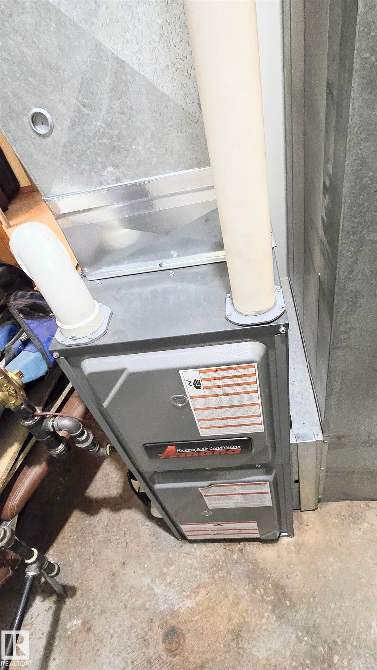 Detailed view of heating unit and concrete floors - 2 4403 Riverbend Road, Edmonton, AB - Indoor Photo Showing Other Room