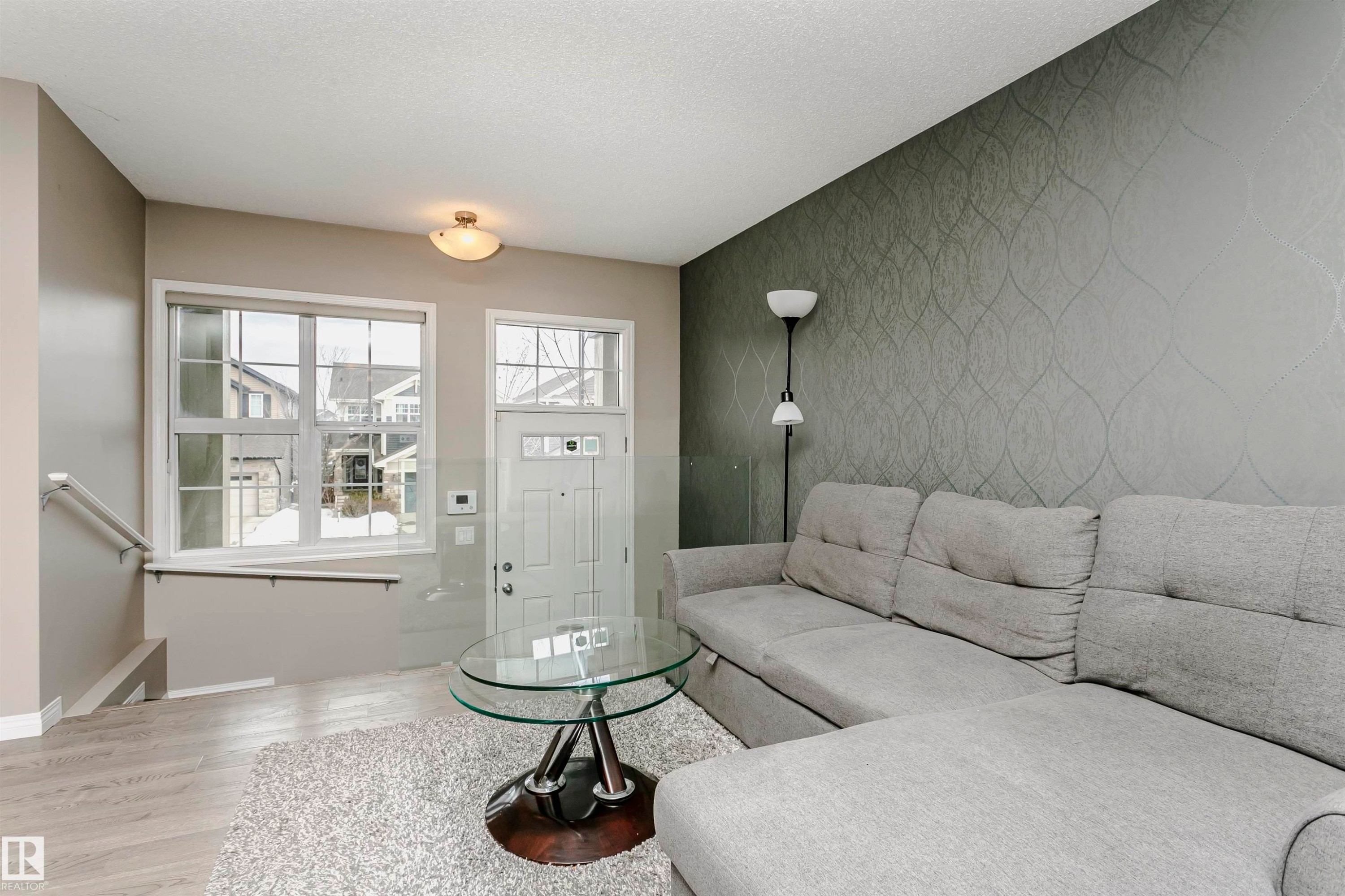 Living room with an accent wall and light wood-style flooring - 4011 Orchards Drive, Edmonton, AB - Indoor Photo Showing Living Room