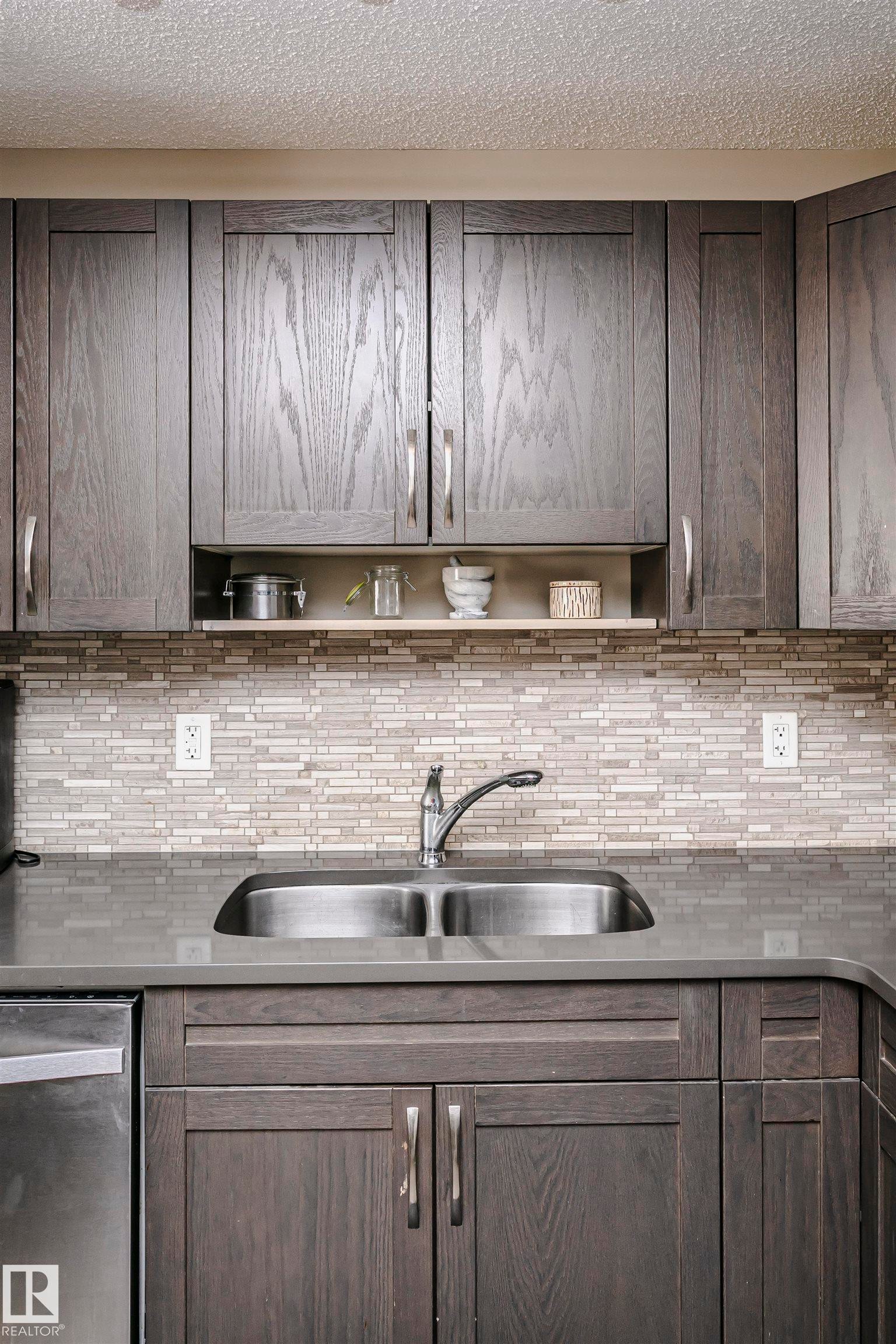 Kitchen with dishwasher, a textured ceiling, open shelves, dark wood finish cabinetry, and backsplash - 4011 Orchards Drive, Edmonton, AB - Indoor Photo Showing Kitchen With Double Sink