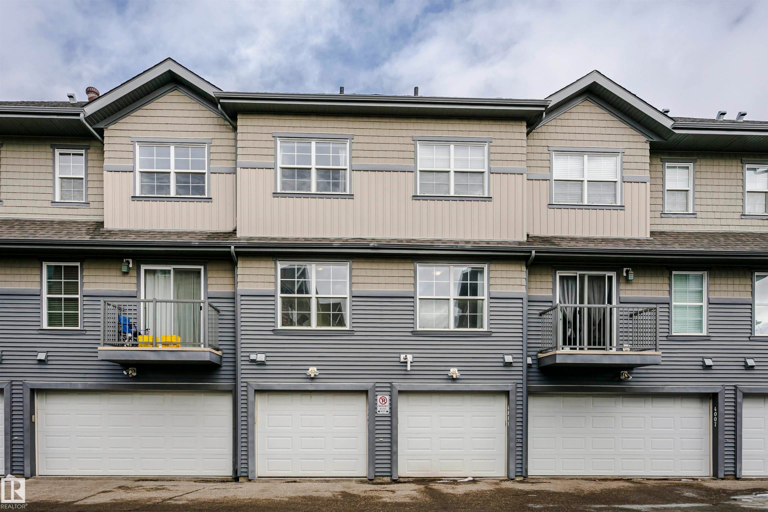 Rear view of house with board and batten siding, an attached garage, and driveway - 4011 Orchards Drive, Edmonton, AB - Outdoor With Facade