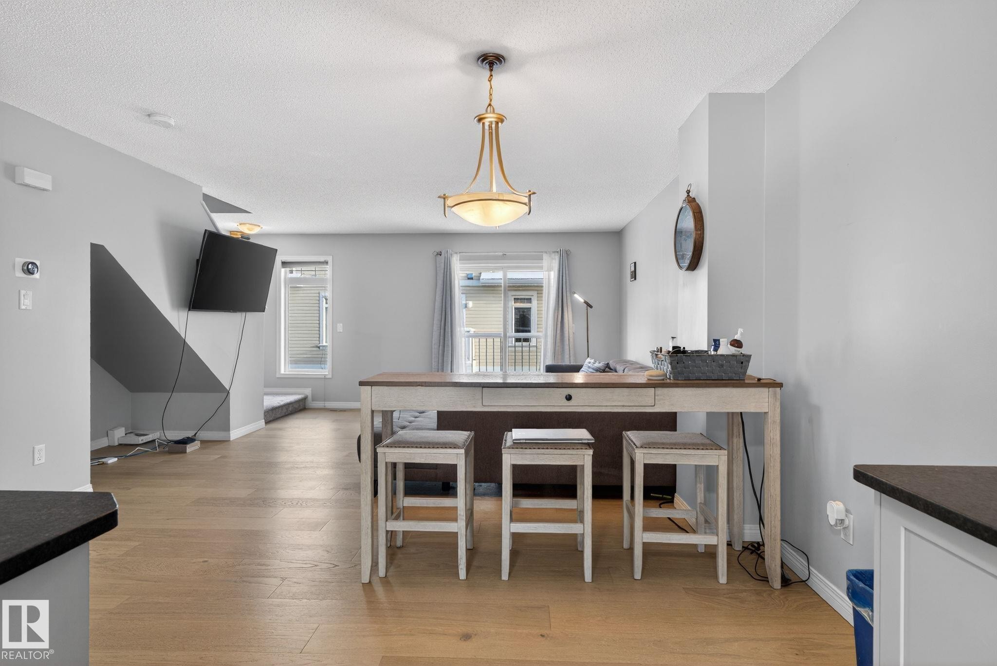 Dining room featuring light wood-style flooring and a textured ceiling - 60 1804 70 Street, Edmonton, AB - Indoor Photo Showing Dining Room