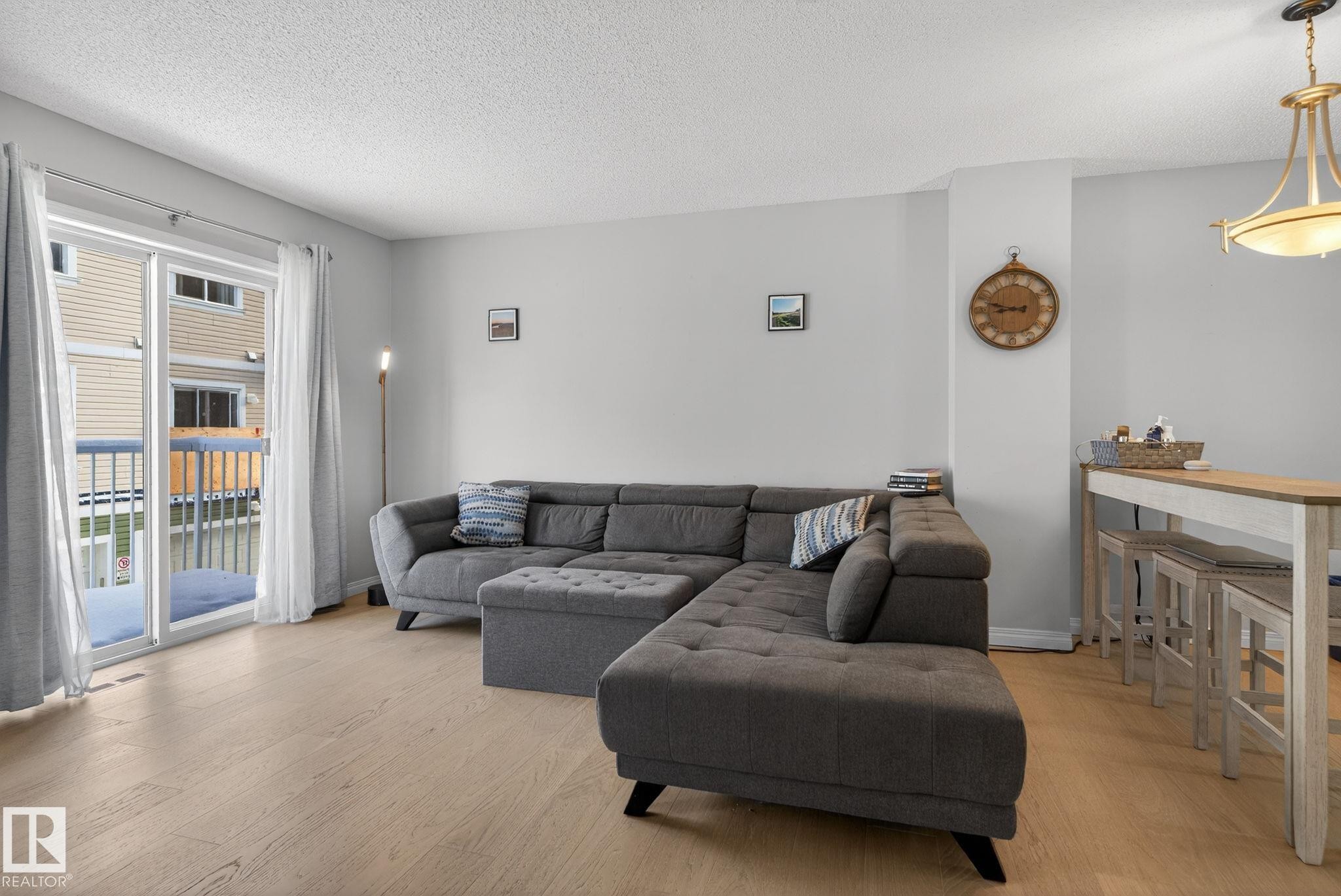 Living area with light wood-style floors and a textured ceiling - 60 1804 70 Street, Edmonton, AB - Indoor Photo Showing Living Room