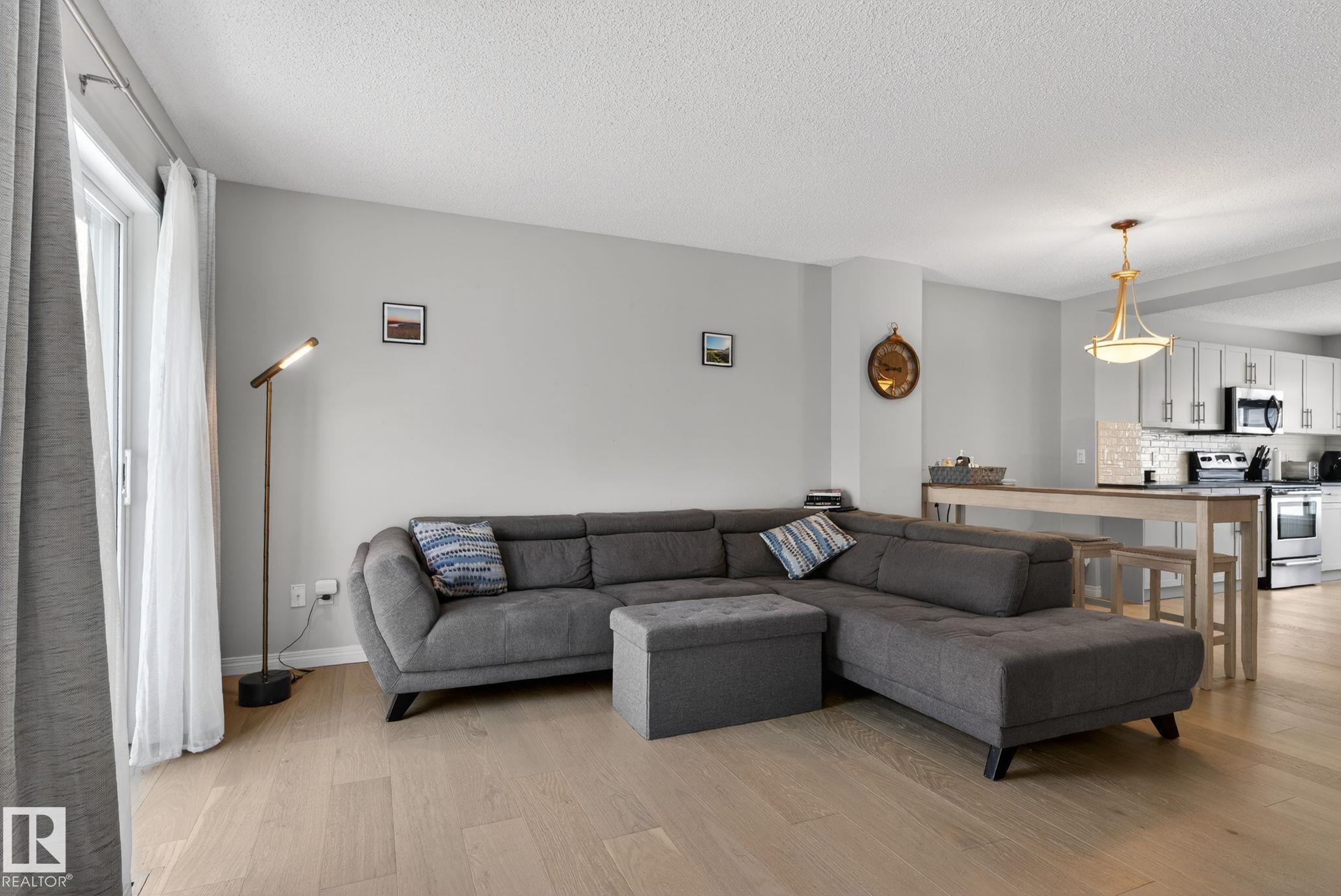 Living room with light wood-style flooring and a textured ceiling - 60 1804 70 Street, Edmonton, AB - Indoor Photo Showing Living Room