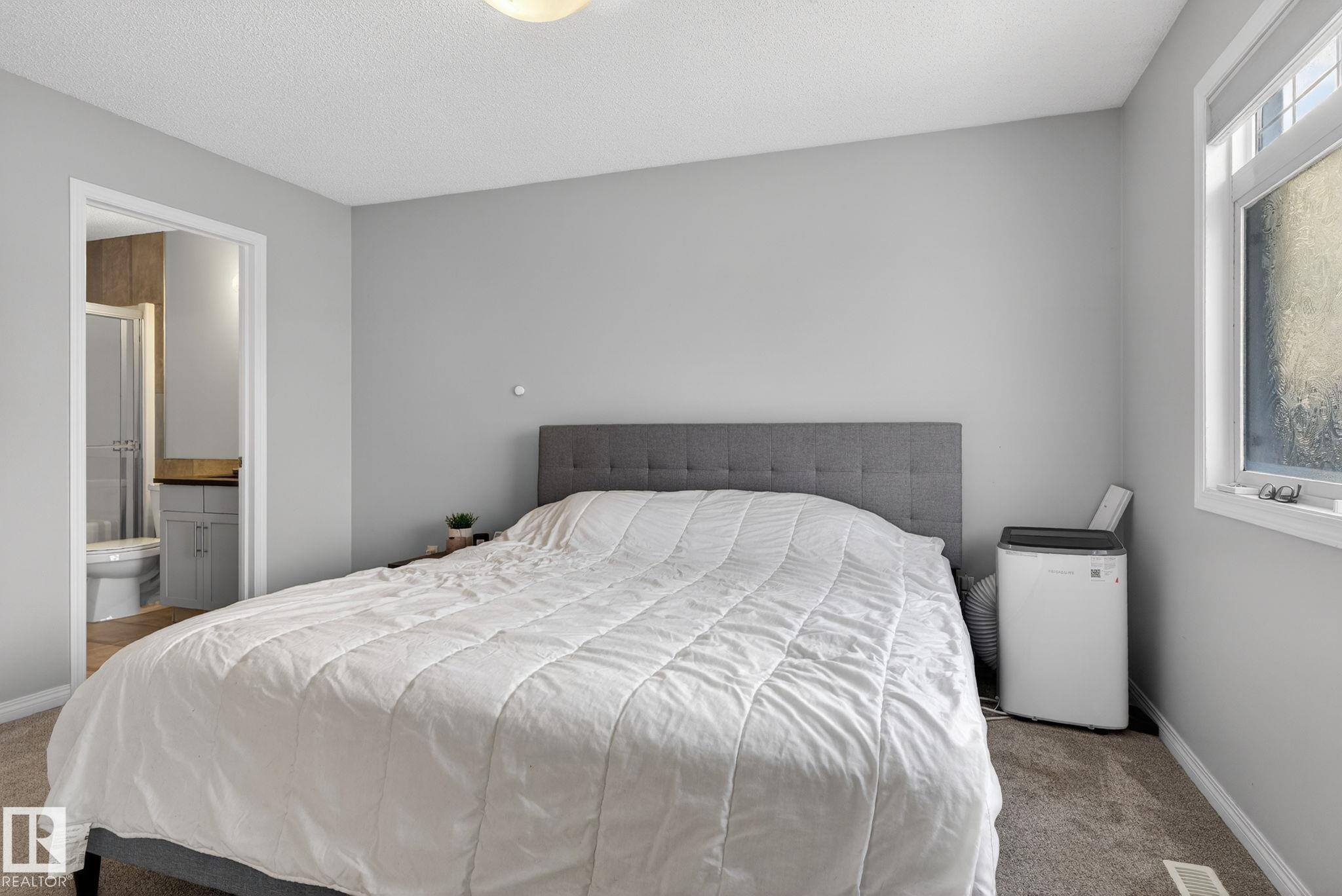 Bedroom featuring carpet, ensuite bathroom, and a textured ceiling - 60 1804 70 Street, Edmonton, AB - Indoor Photo Showing Bedroom