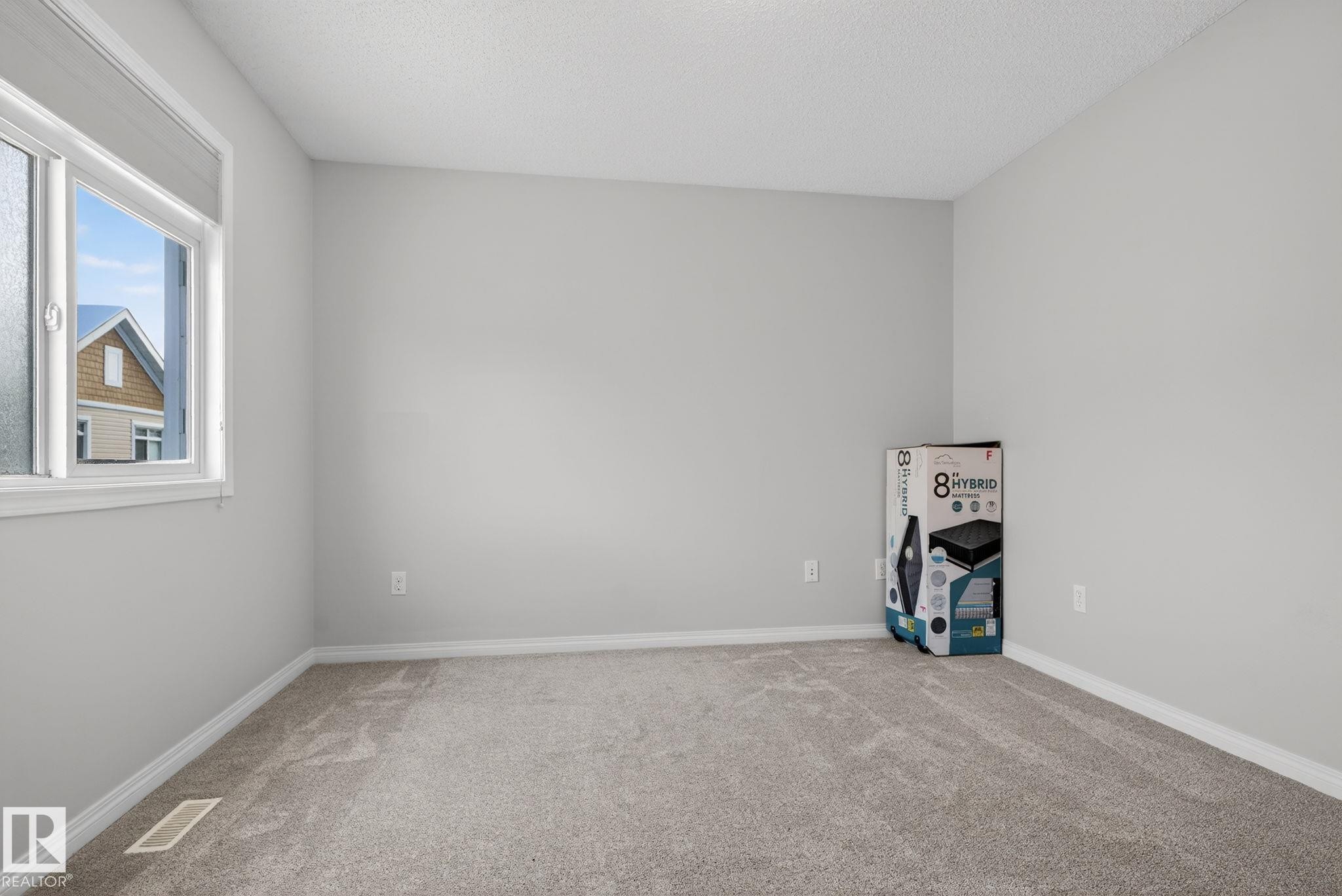 Carpeted spare room featuring a textured ceiling - 60 1804 70 Street, Edmonton, AB - Indoor Photo Showing Other Room
