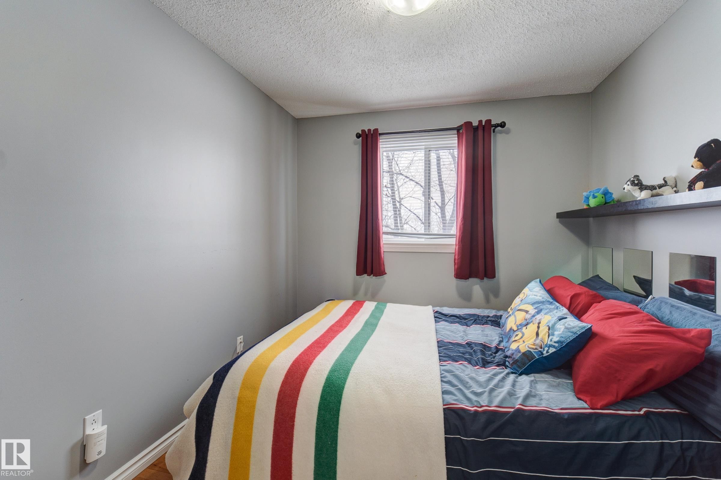 Bedroom with a textured ceiling and baseboards - 4823 10 Avenue, Edmonton, AB - Indoor Photo Showing Bedroom