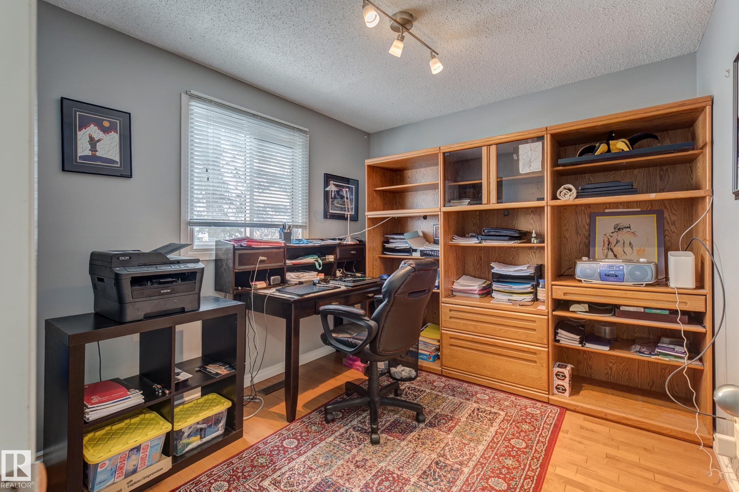 Home office featuring light wood-style floors, rail lighting, and a textured ceiling - 4823 10 Avenue, Edmonton, AB - Indoor Photo Showing Office