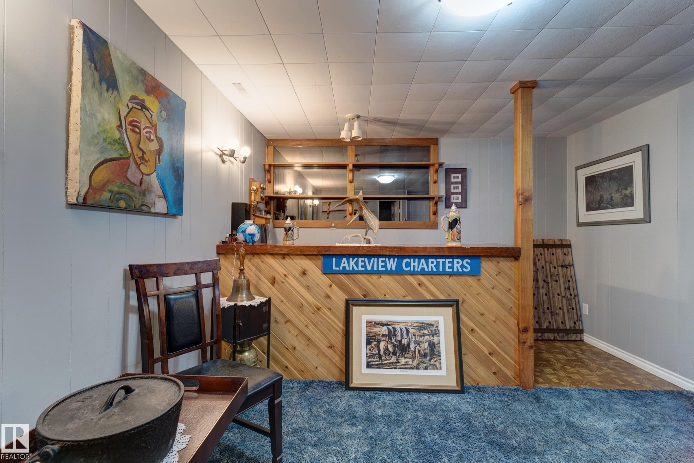 Carpeted living area featuring bar area and wooden walls - 4823 10 Avenue, Edmonton, AB - Indoor Photo Showing Other Room With Fireplace