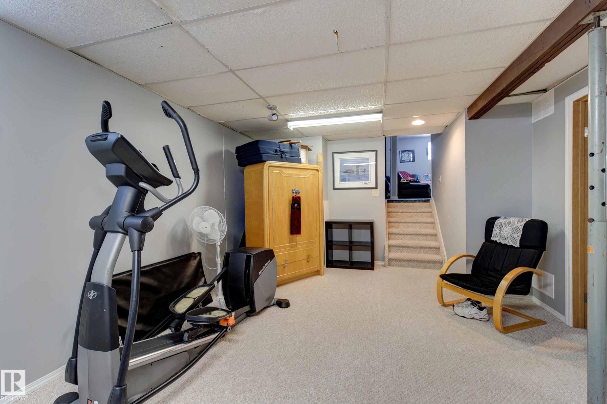 Exercise room featuring light colored carpet and a paneled ceiling - 4823 10 Avenue, Edmonton, AB - Indoor Photo Showing Gym Room