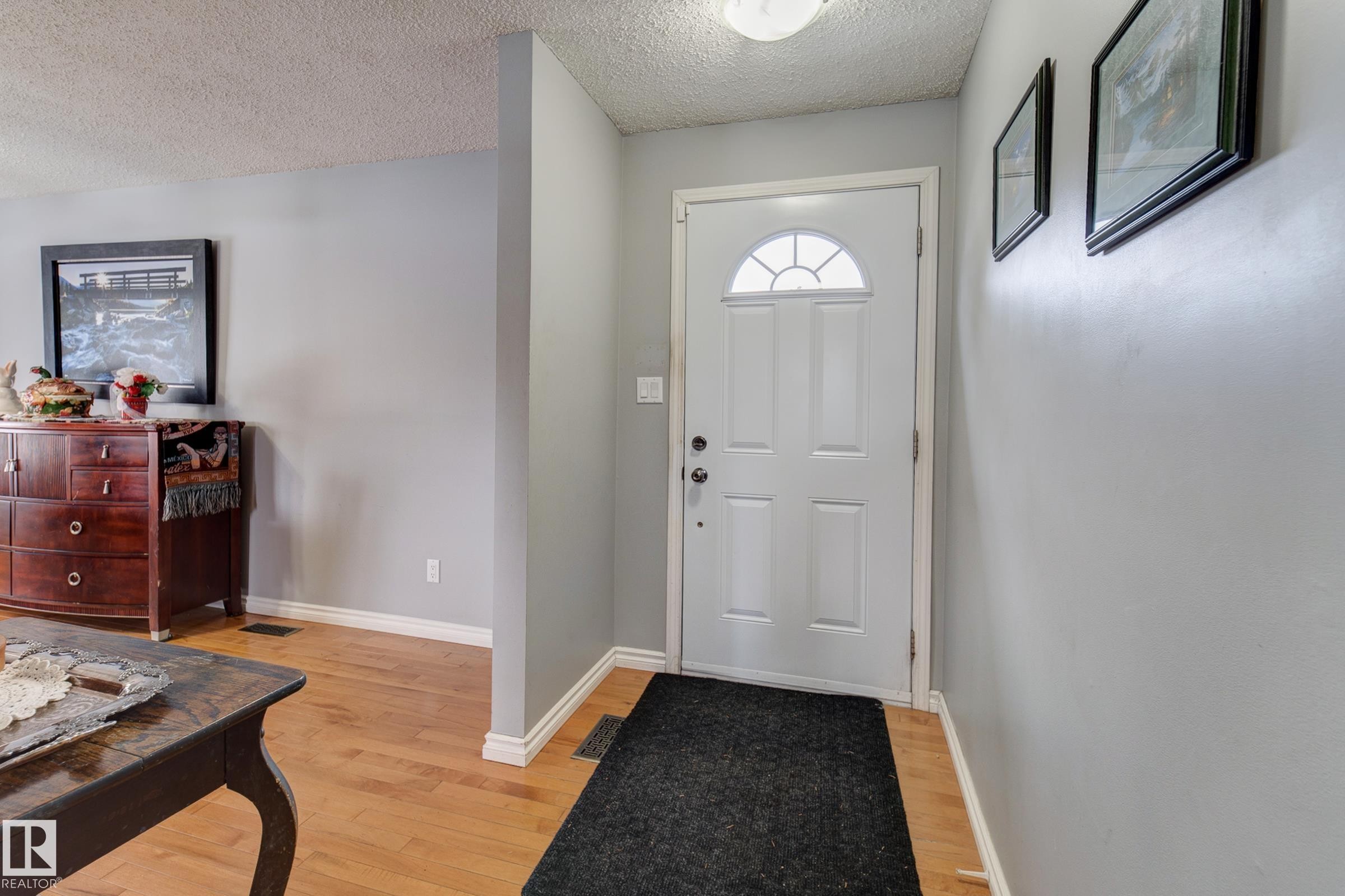 Entryway with light wood-style floors and a textured ceiling - 4823 10 Avenue, Edmonton, AB - Indoor Photo Showing Other Room