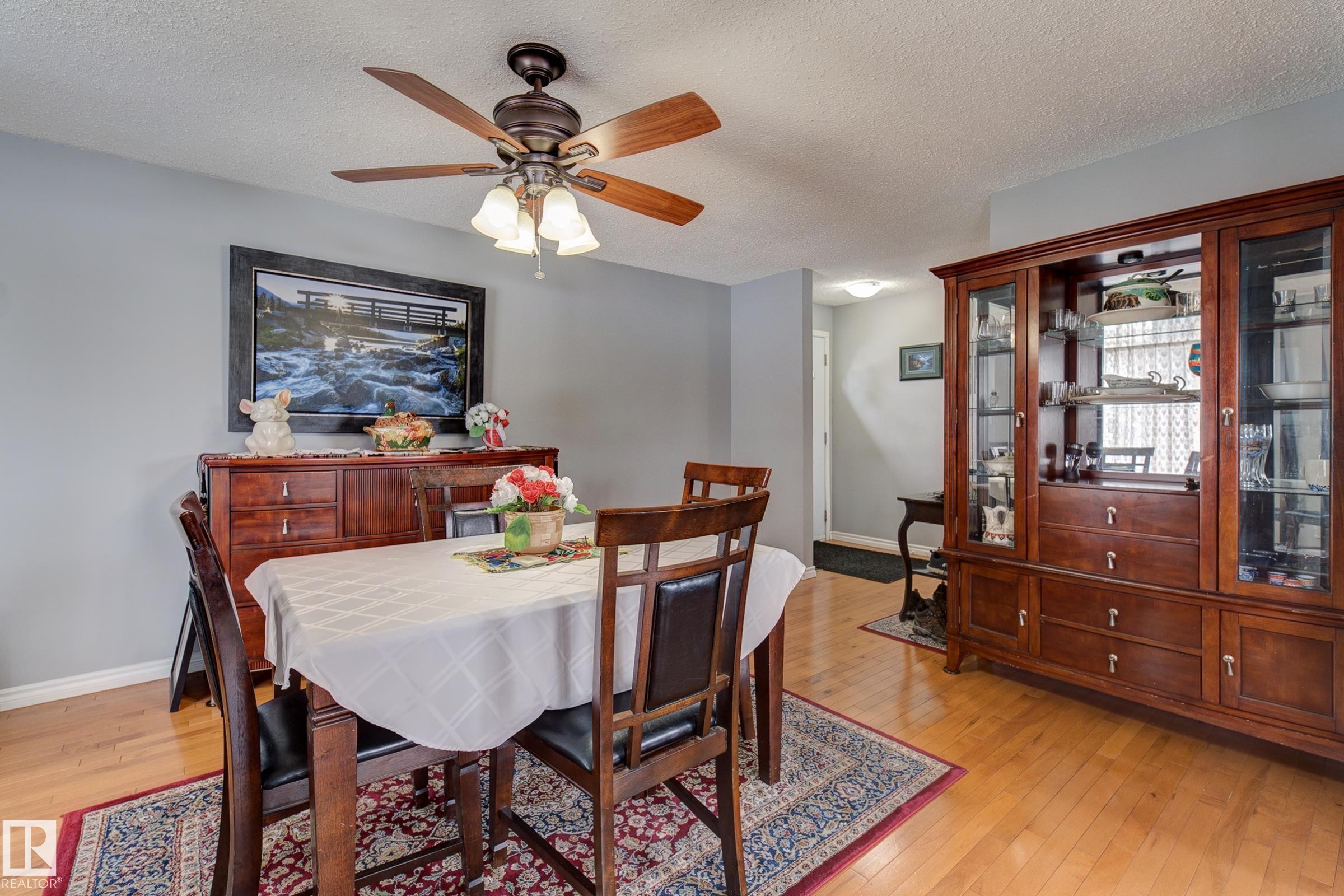 Dining area featuring light wood-style flooring, a textured ceiling, and a ceiling fan - 4823 10 Avenue, Edmonton, AB - Indoor Photo Showing Dining Room
