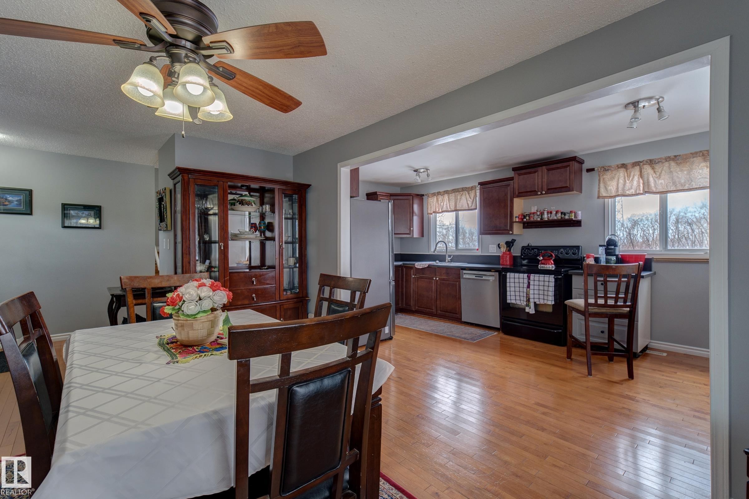 Dining room featuring light wood-style floors, a textured ceiling, and ceiling fan - 4823 10 Avenue, Edmonton, AB - Indoor Photo Showing Dining Room
