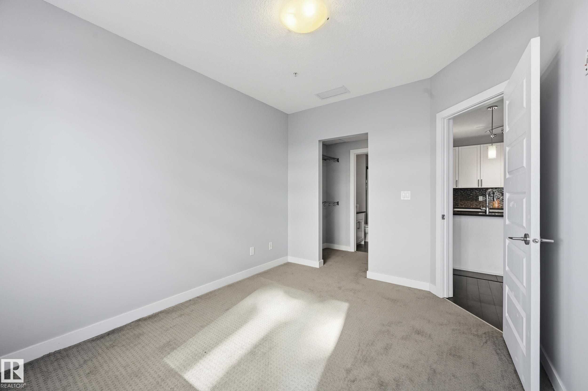 Unfurnished bedroom with carpet floors and baseboards - 511 5151 Windermere Boulevard, Edmonton, AB - Indoor