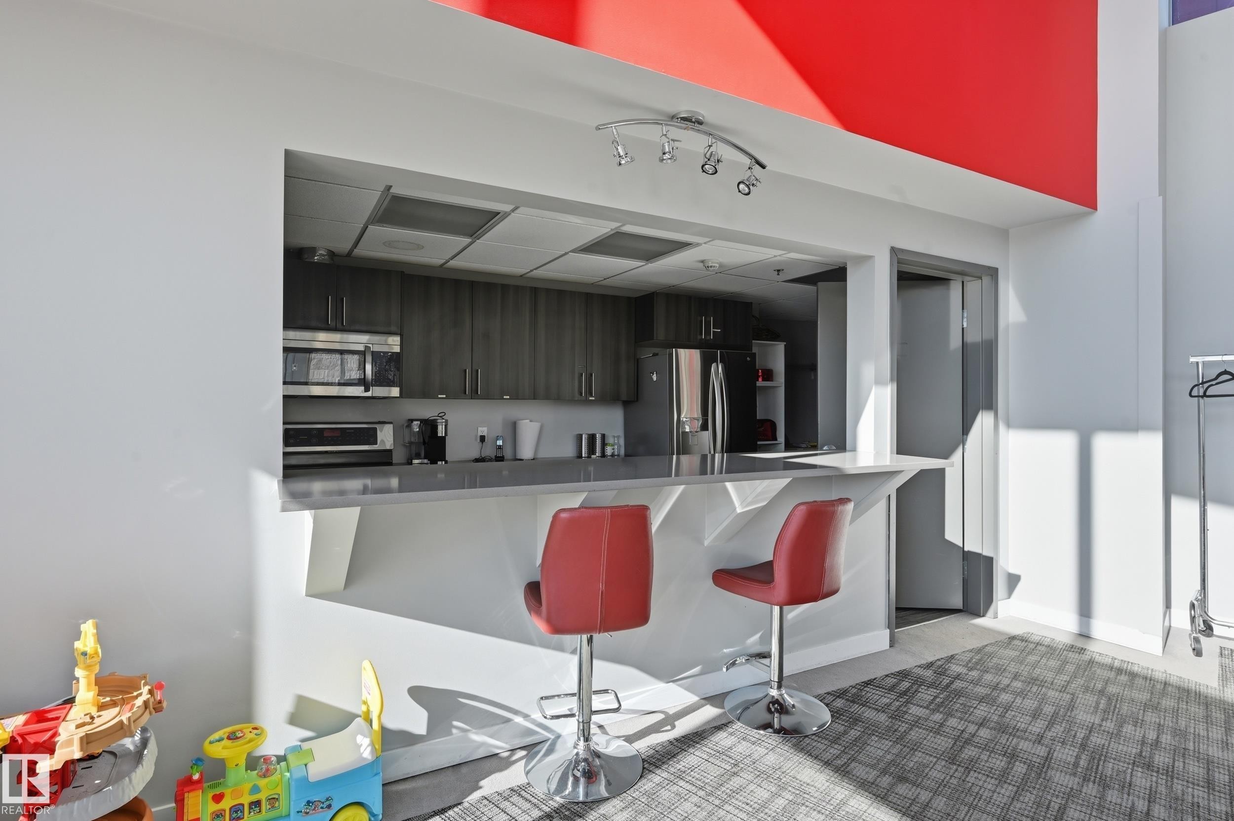 Kitchen with a kitchen bar, stainless steel appliances, and a peninsula - 511 5151 Windermere Boulevard, Edmonton, AB - Indoor Photo Showing Kitchen