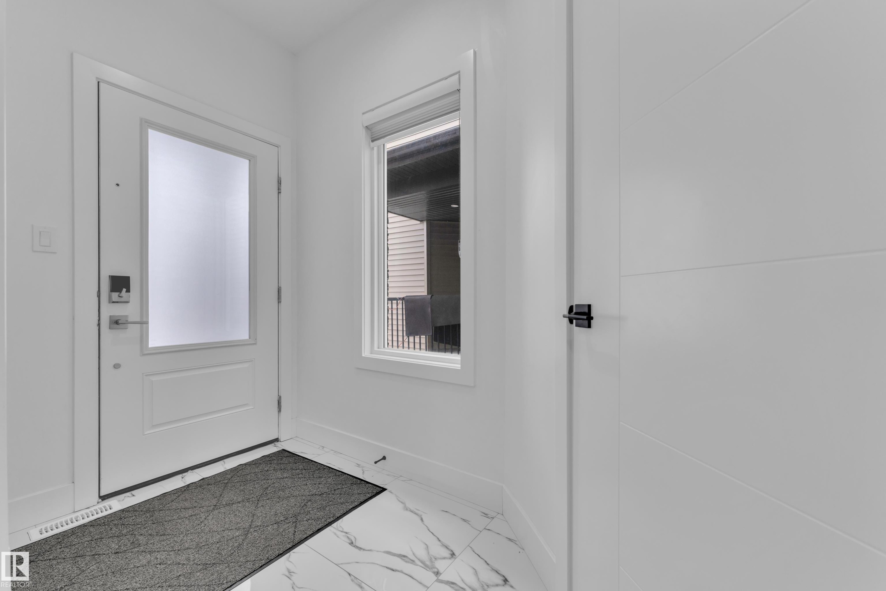 Entryway with baseboards and marble look tile flooring - 16812 48 Street Nw, Edmonton, AB - Indoor Photo Showing Other Room
