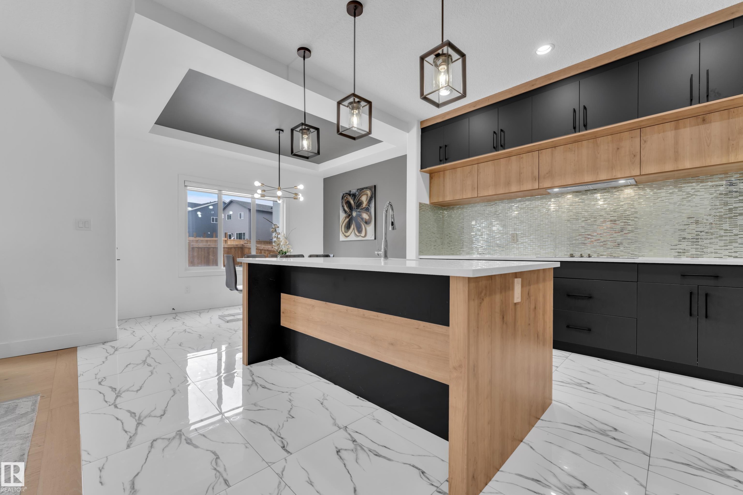 Two tone kitchen featuring two tone color scheme, light marble finish floors, a kitchen island, a tray ceiling, and decorative backsplash - 16812 48 Street Nw, Edmonton, AB - Indoor Photo Showing Kitchen