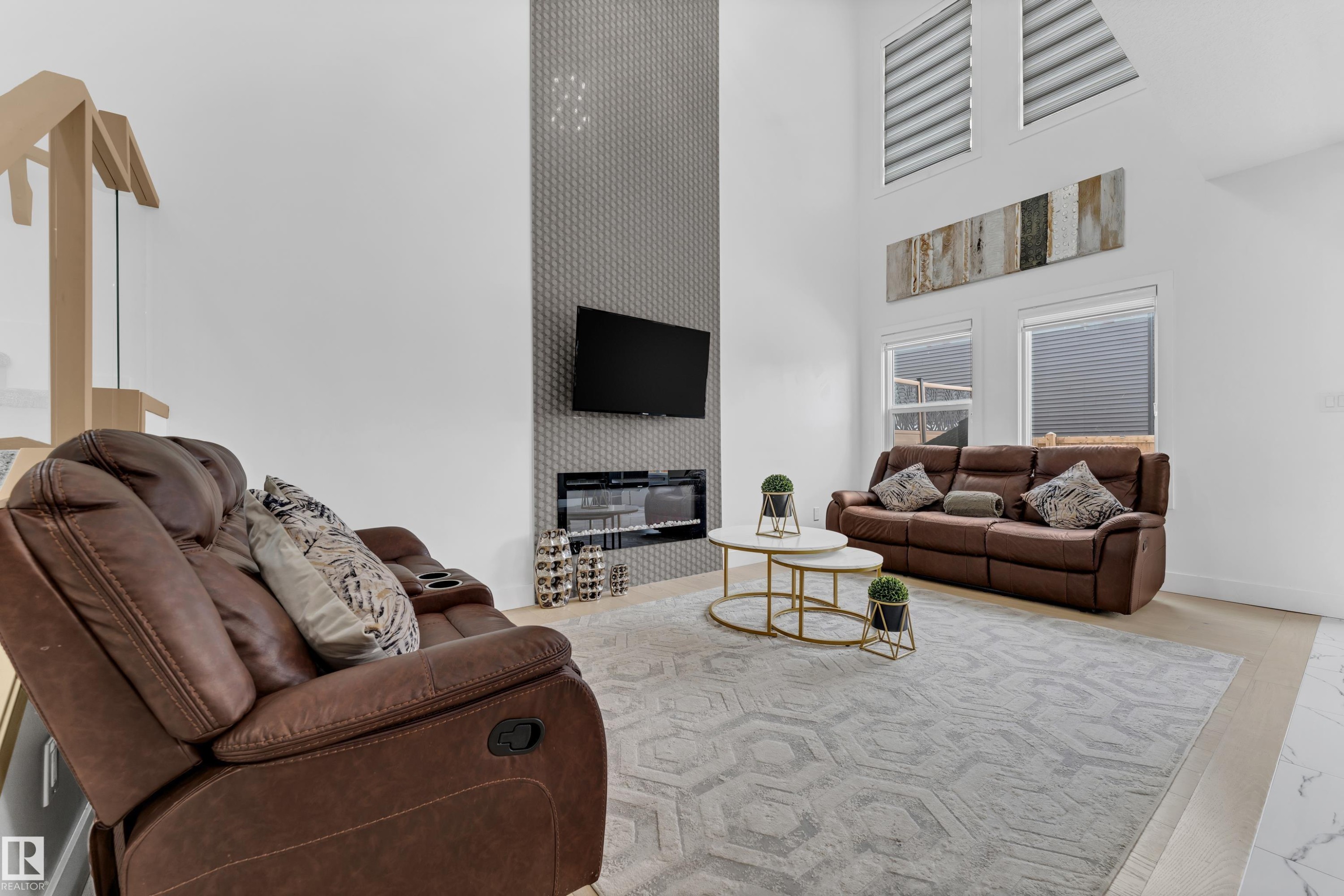 Living area with a high ceiling, a large fireplace, and an accent wall - 16812 48 Street Nw, Edmonton, AB - Indoor Photo Showing Living Room With Fireplace