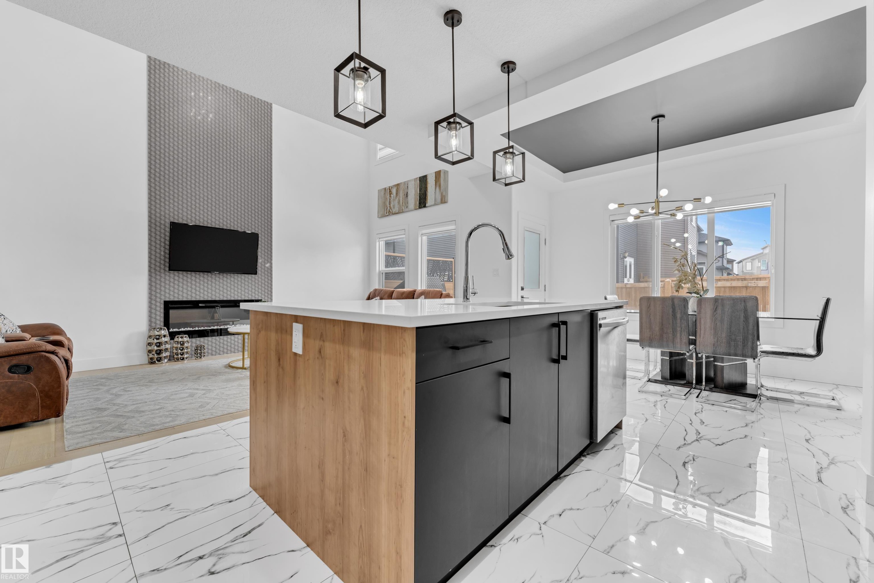 Kitchen featuring a center island with sink, open floor plan, modern cabinets, and light marble finish flooring - 16812 48 Street Nw, Edmonton, AB - Indoor Photo Showing Kitchen With Upgraded Kitchen