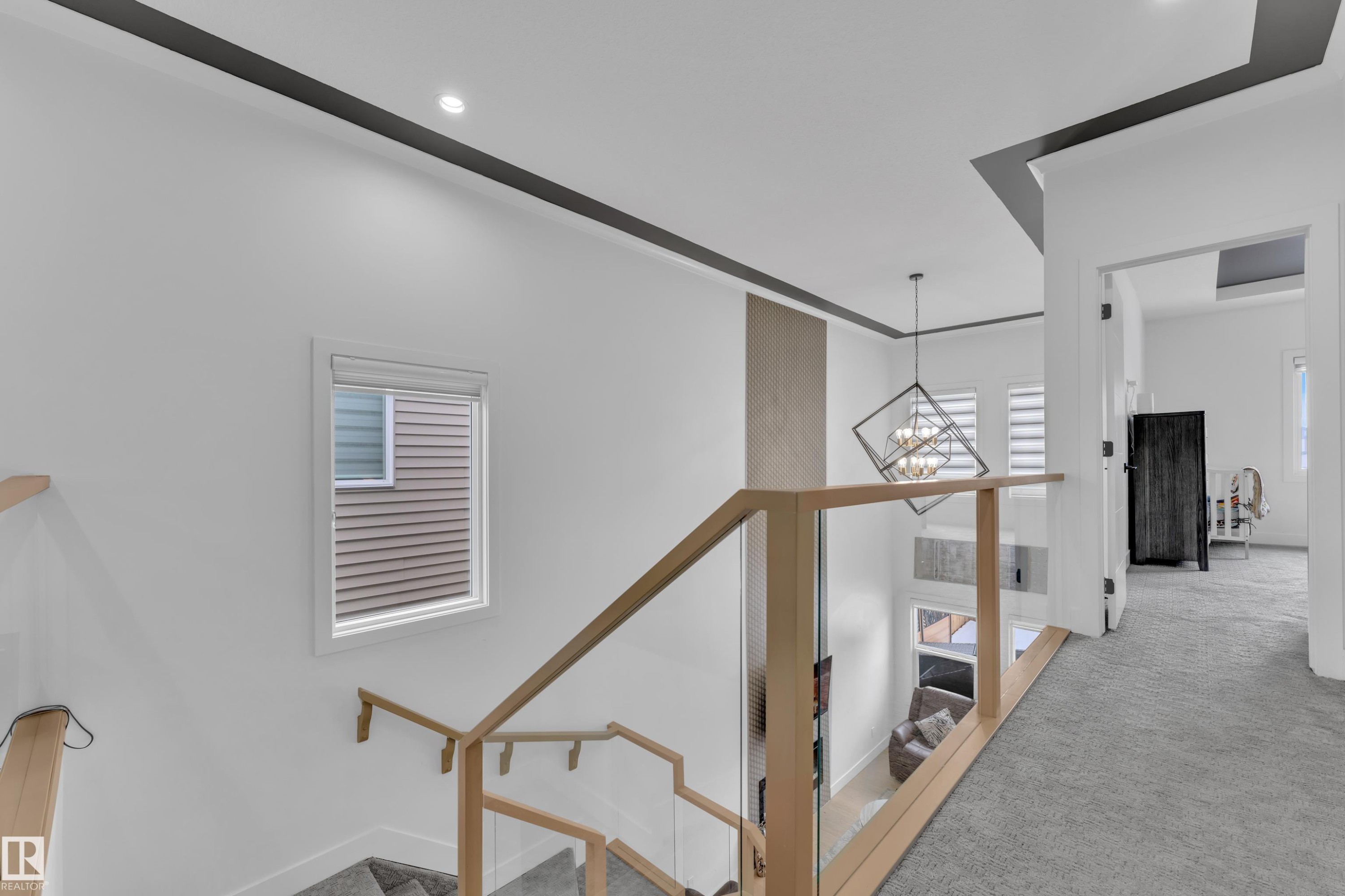 Hall featuring light carpet, an upstairs landing, and a chandelier - 16812 48 Street Nw, Edmonton, AB - Indoor Photo Showing Other Room