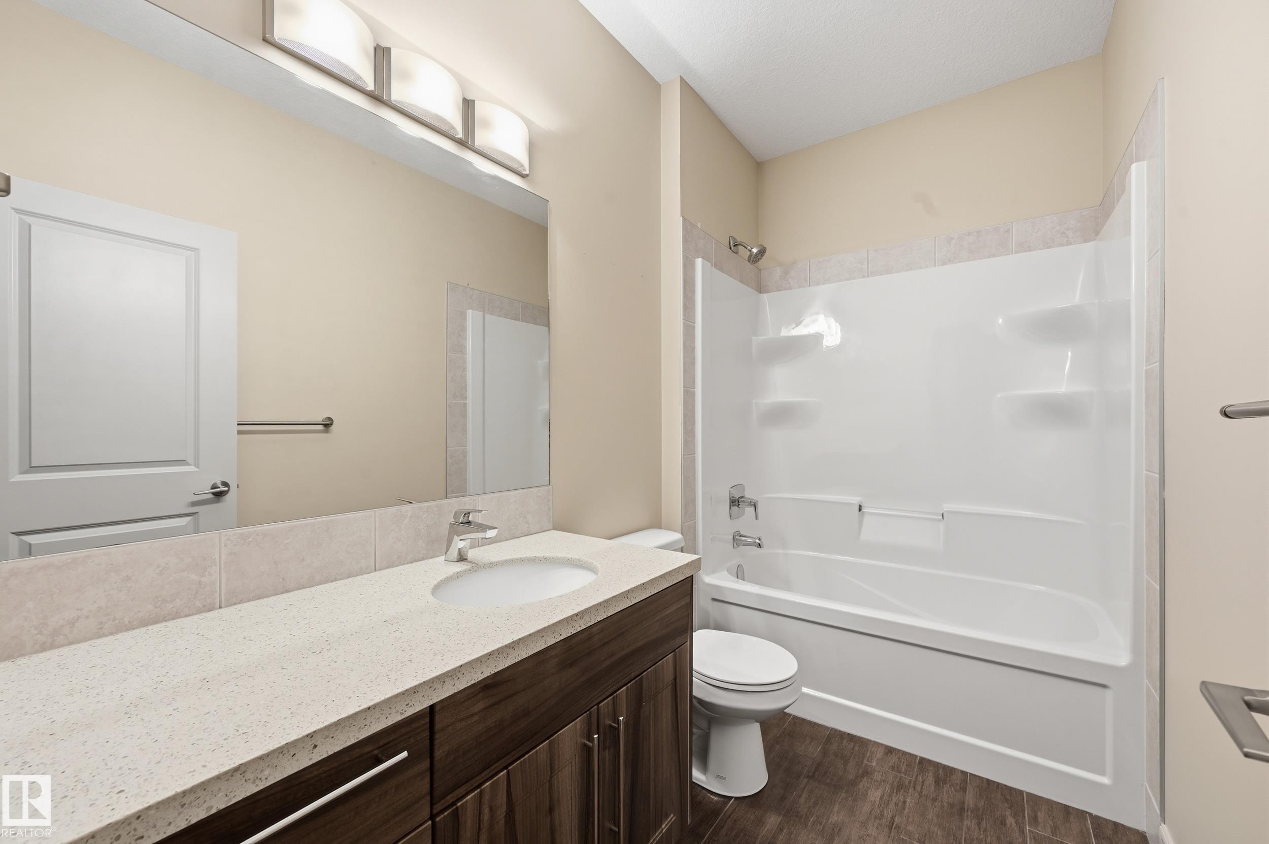 Bathroom with vanity, shower combination, and dark wood finished floors - 1346 Cunningham Drive W, Edmonton, AB - Indoor Photo Showing Bathroom